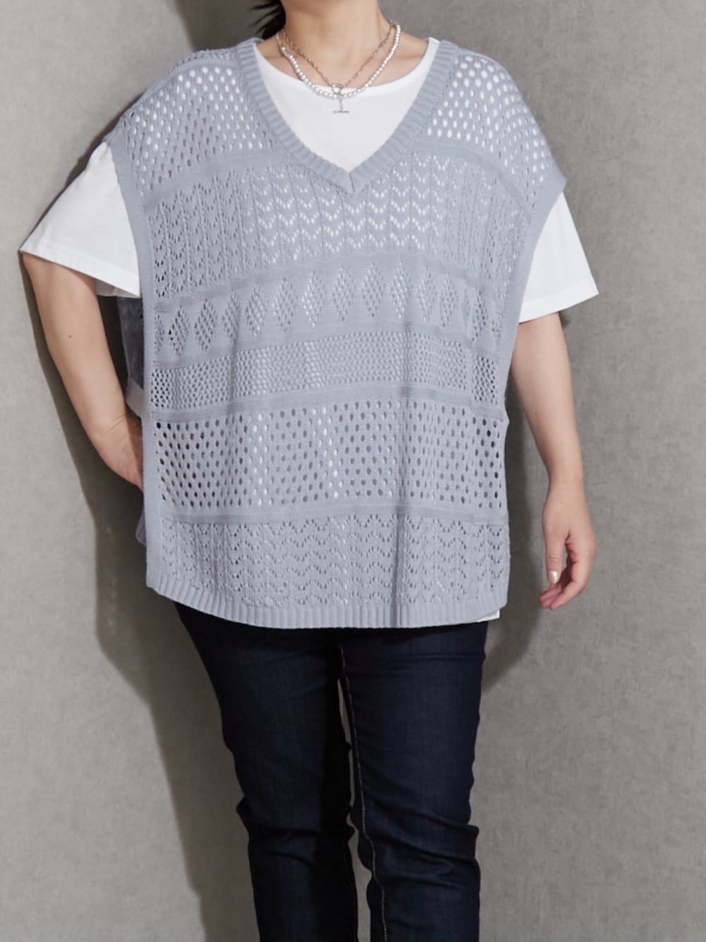 グレー系のスニーカー、ブルー系のデニムパンツ、ブルー系のニット/セーターを着用したレディースの夏コーディネートの3枚目の写真