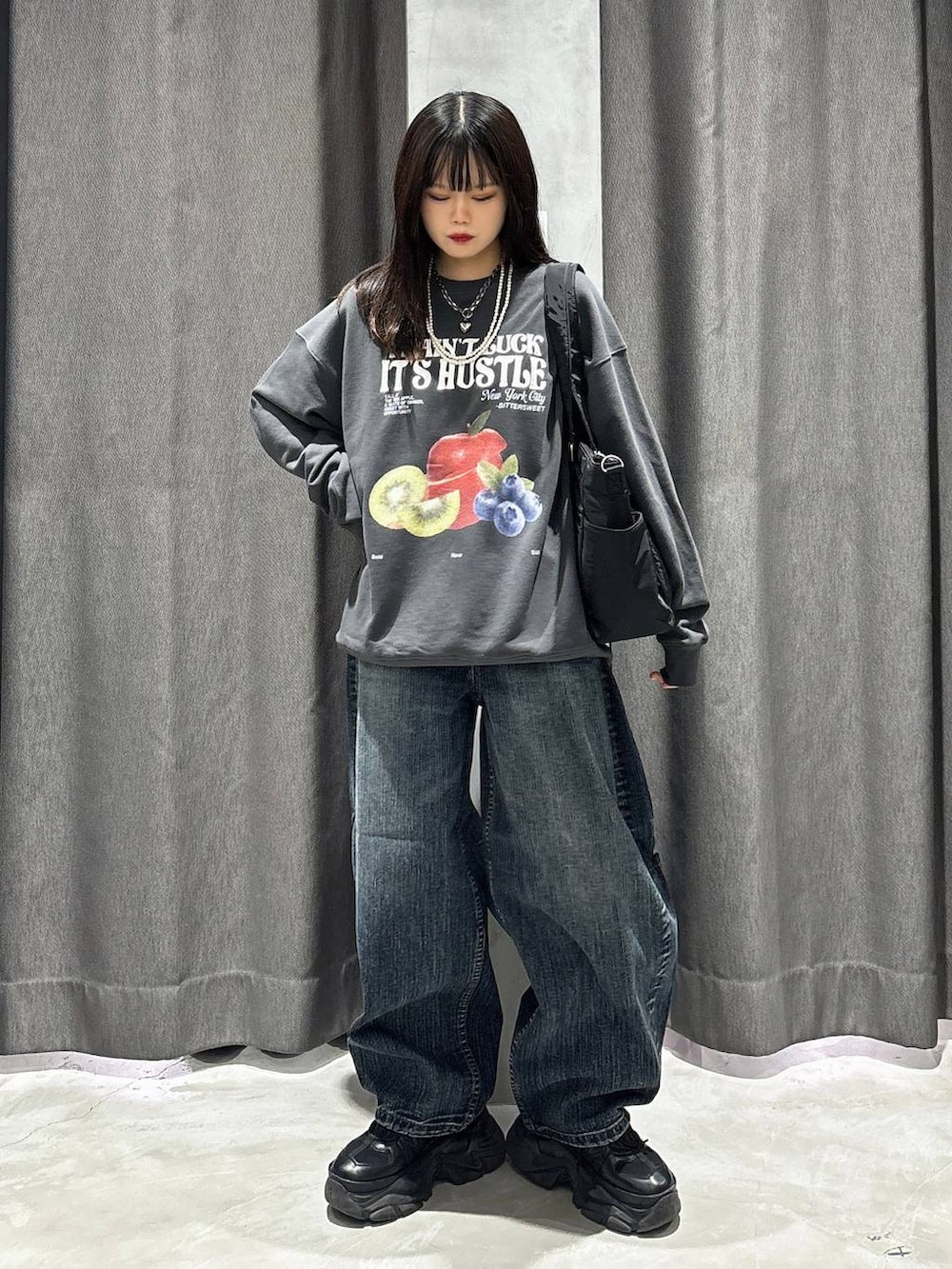 ブラック系のスニーカー、ブラック系のボストンバッグ、ブラック系のスウェットを着用したレディースの秋コーディネートの2枚目の写真