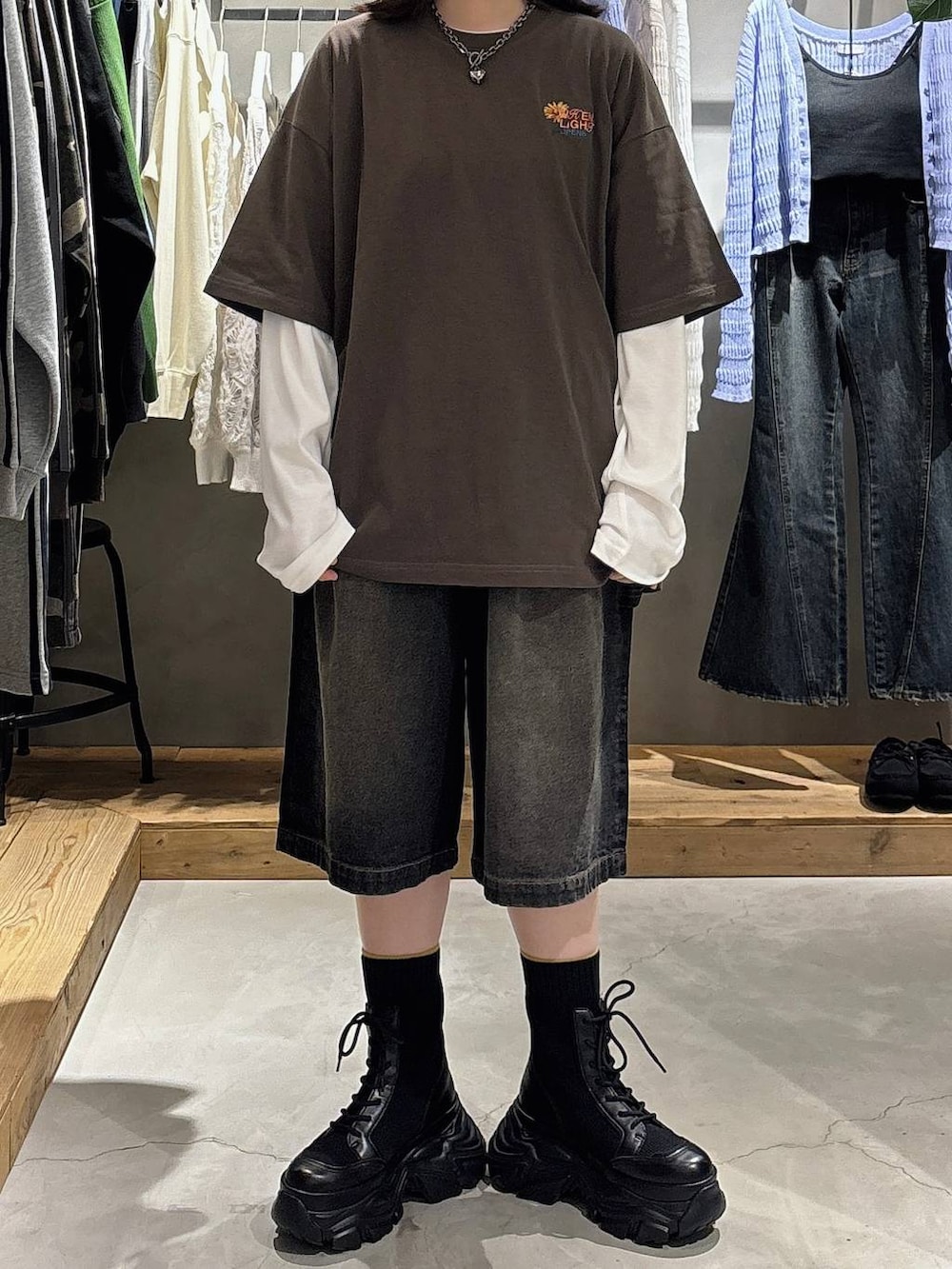 ブラック系のブーツ、ホワイト系のTシャツ/カットソー、ブラウン系のTシャツ/カットソーを着用したレディースの春コーディネートの3枚目の写真