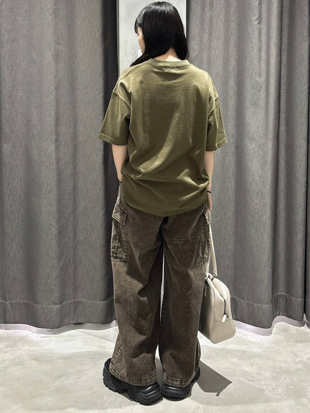 ホワイト系のボストンバッグ、グリーン系のTシャツ/カットソー、ブラウン系のカーゴパンツを着用したレディースの春コーディネートの4枚目の写真