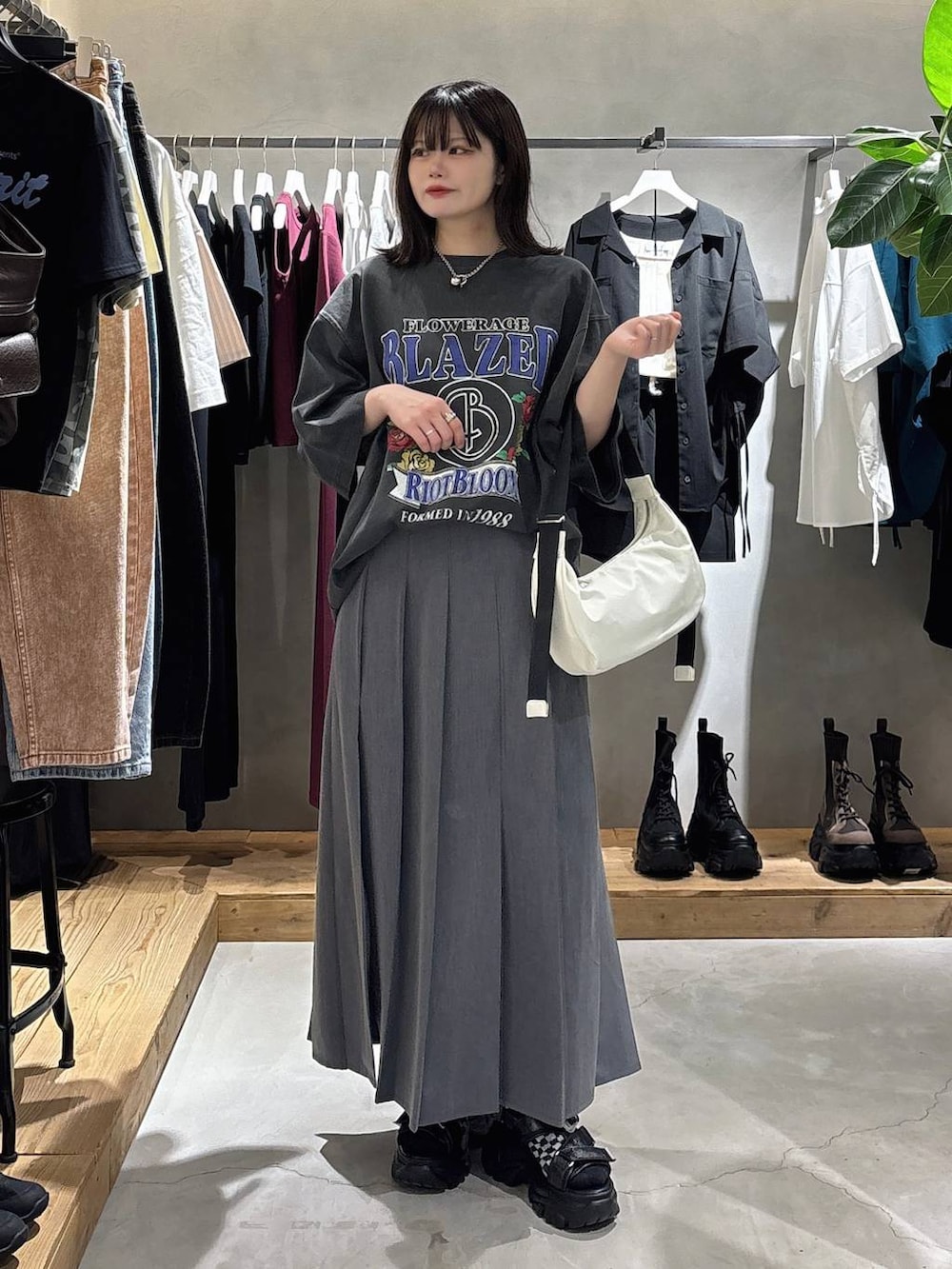 ブラック系のサンダル、グレー系のスカート、シルバー系のネックレスを着用したレディースの春コーディネートの3枚目の写真