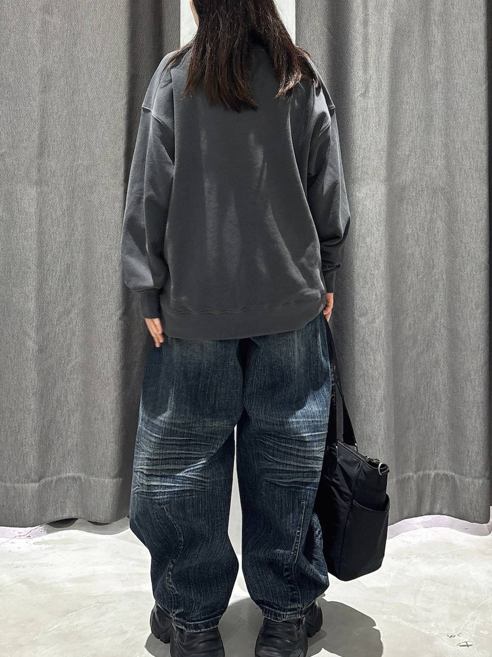 ブラック系のスニーカー、ブラック系のボストンバッグ、ブラック系のスウェットを着用したレディースの秋コーディネートの4枚目の写真