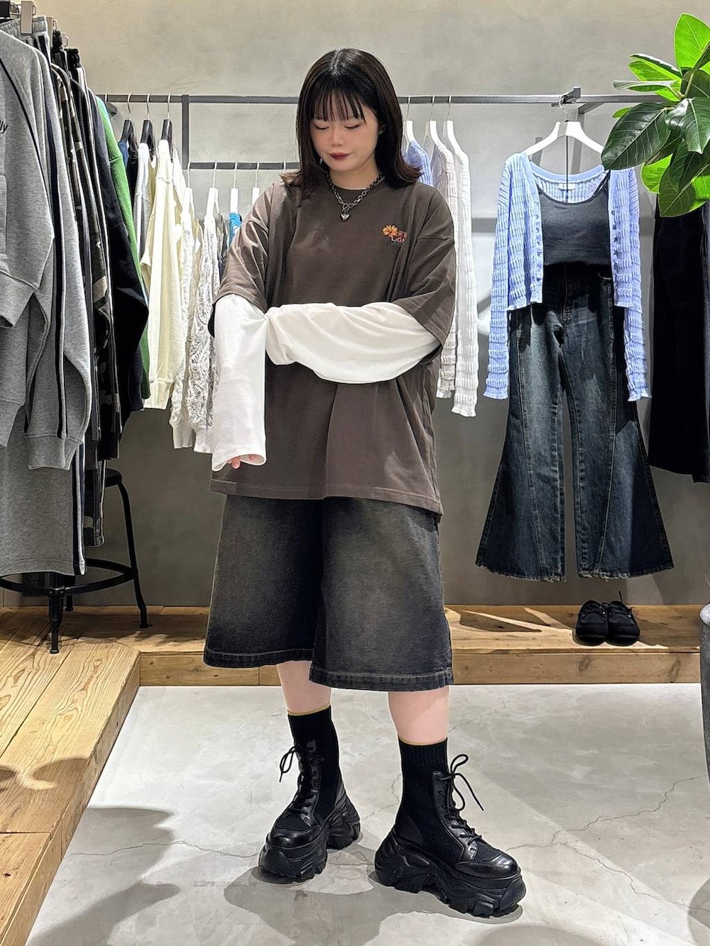 ブラック系のブーツ、ホワイト系のTシャツ/カットソー、ブラウン系のTシャツ/カットソーを着用したレディースの春コーディネートの2枚目の写真