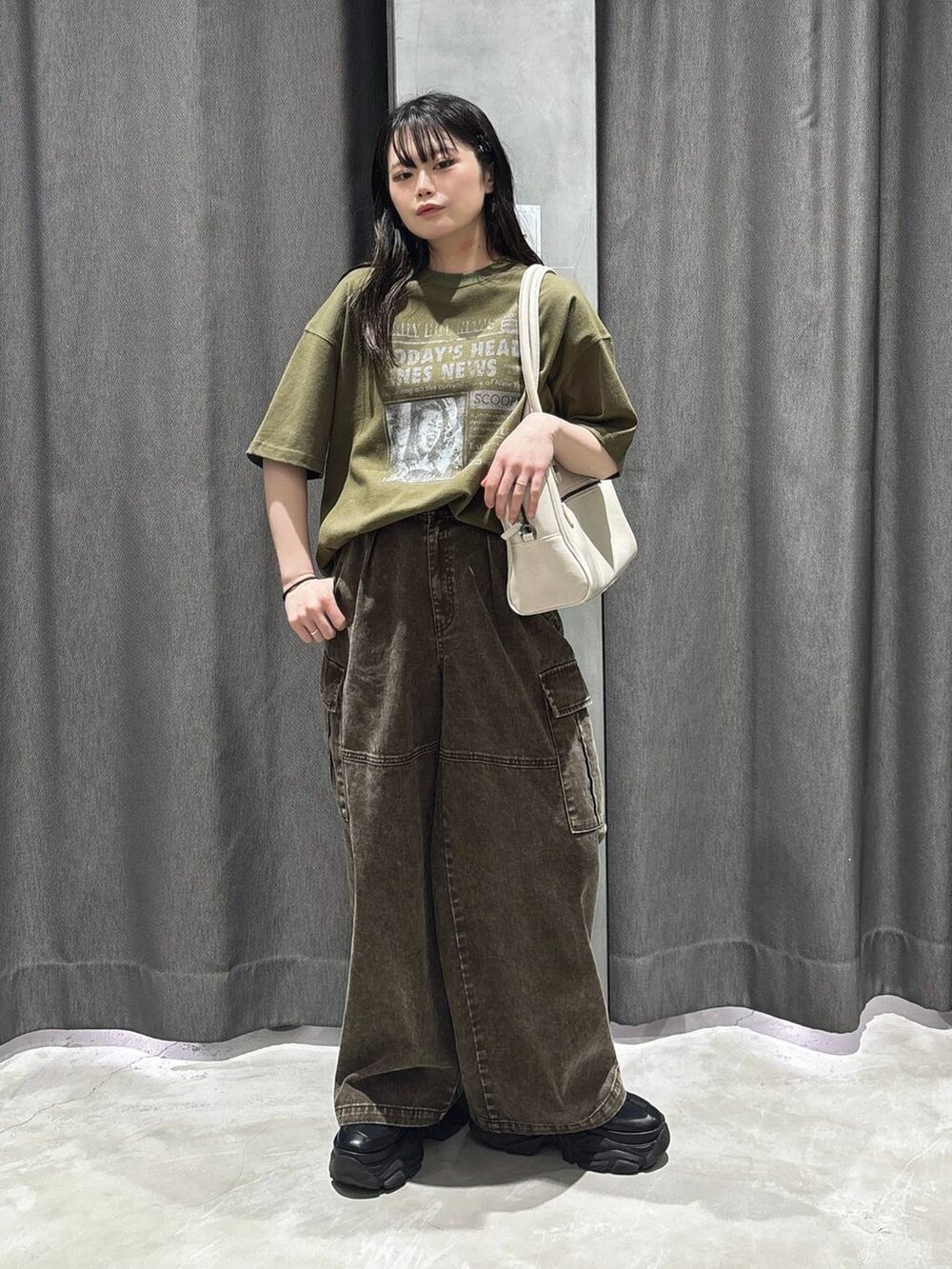 ホワイト系のボストンバッグ、グリーン系のTシャツ/カットソー、ブラウン系のカーゴパンツを着用したレディースの春コーディネートの2枚目の写真