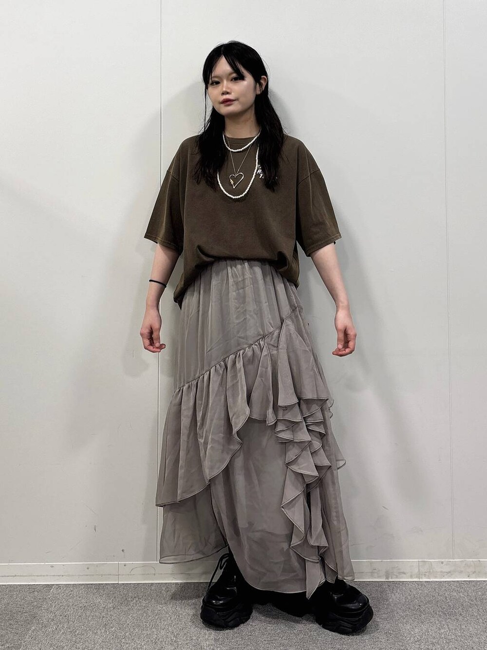 グレー系のスカート、ブラウン系のTシャツ/カットソーを着用したレディースの夏コーディネートの2枚目の写真