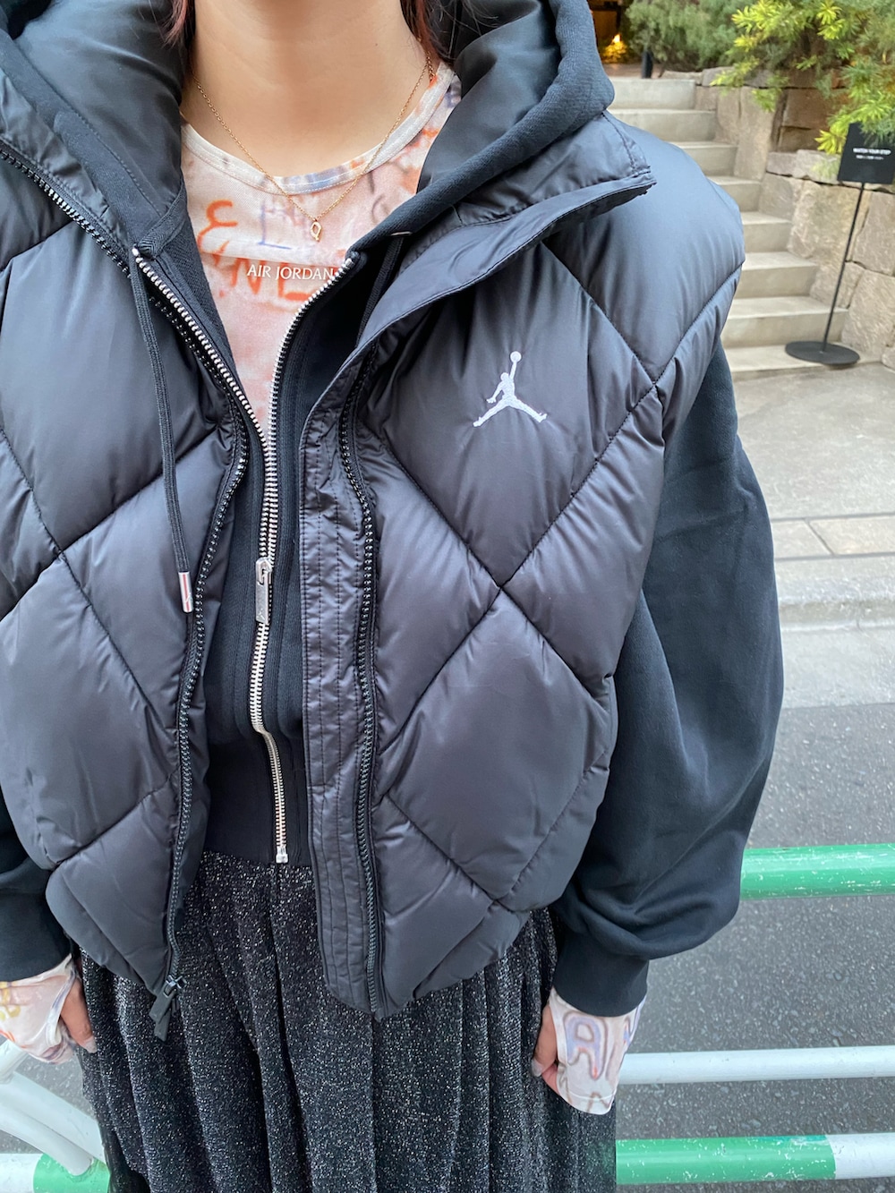 ブラック系のダウンベスト、ホワイト系のトップス、ブラック系のスウェットを着用したレディースの秋コーディネートの4枚目の写真