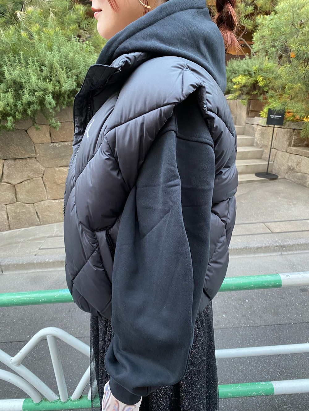 ブラック系のダウンベスト、ホワイト系のトップス、ブラック系のスウェットを着用したレディースの秋コーディネートの5枚目の写真