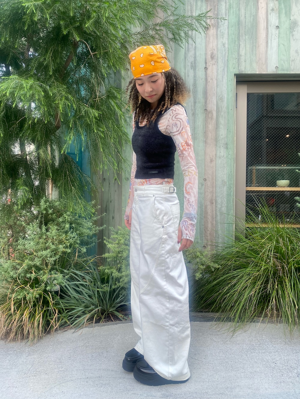 ブラック系のタンクトップ、オレンジ系のその他トップス、ホワイト系のパンツを着用したレディースの秋コーディネートの2枚目の写真