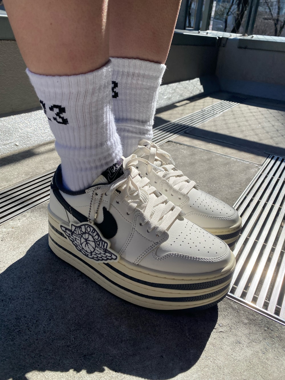 ブラック系のワンピース、ブラック系のジャケット/アウター、ホワイト系のスニーカーを着用したレディースの冬コーディネートの4枚目の写真