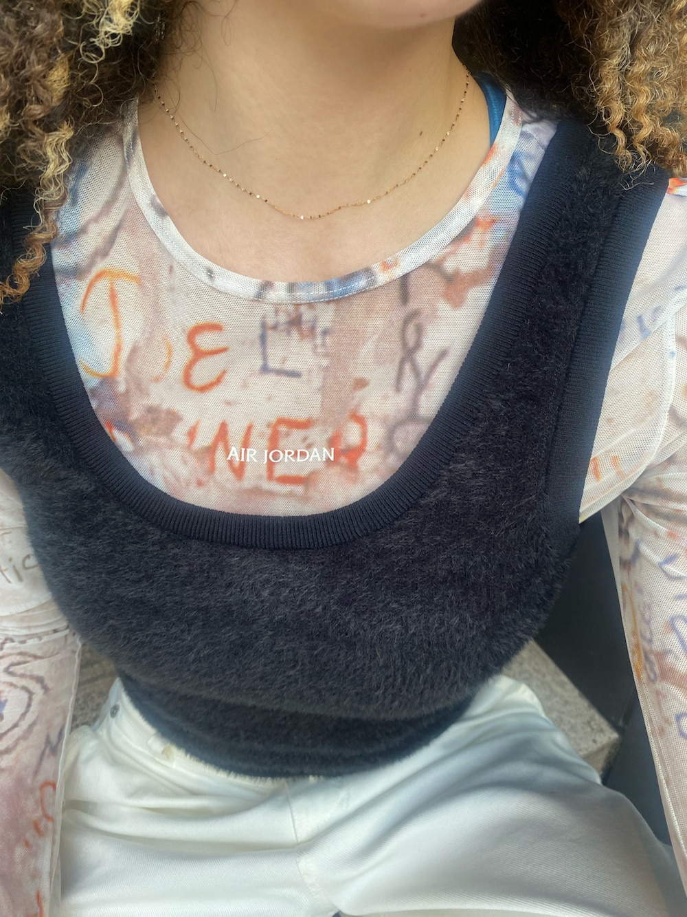 ブラック系のタンクトップ、オレンジ系のその他トップス、ホワイト系のパンツを着用したレディースの秋コーディネートの5枚目の写真