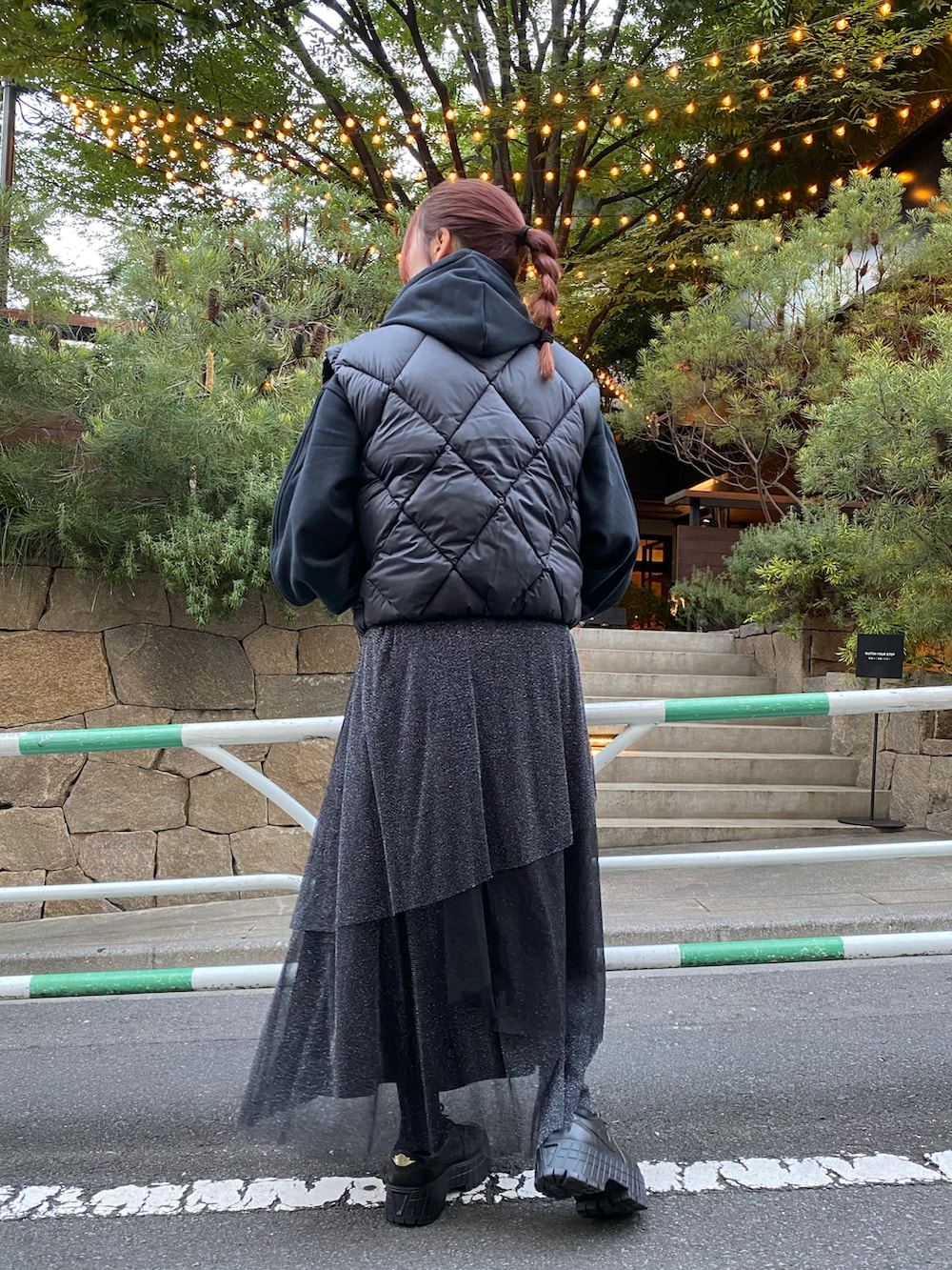 ブラック系のダウンベスト、ホワイト系のトップス、ブラック系のスウェットを着用したレディースの秋コーディネートの3枚目の写真