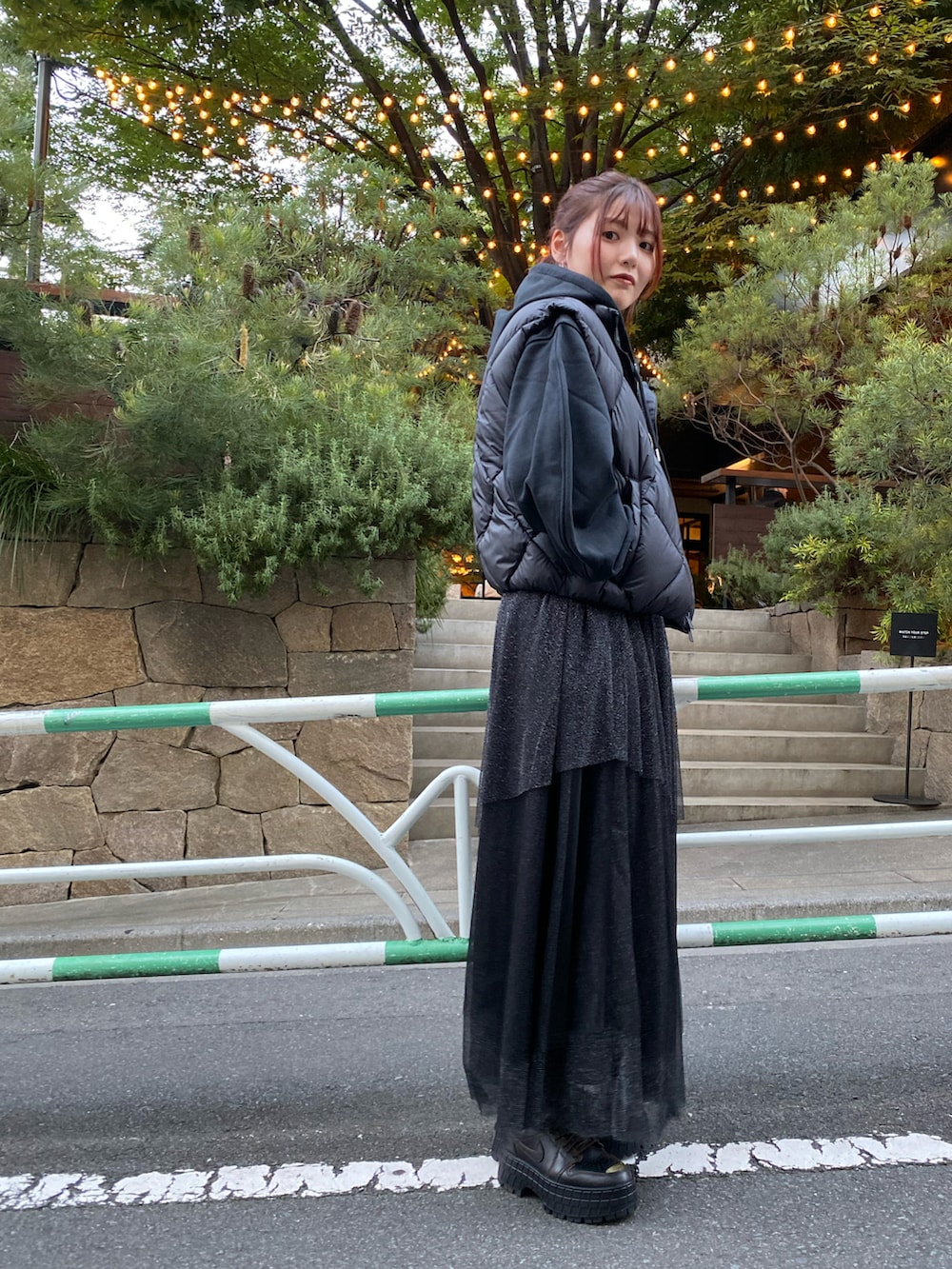 ブラック系のダウンベスト、ホワイト系のトップス、ブラック系のスウェットを着用したレディースの秋コーディネートの2枚目の写真