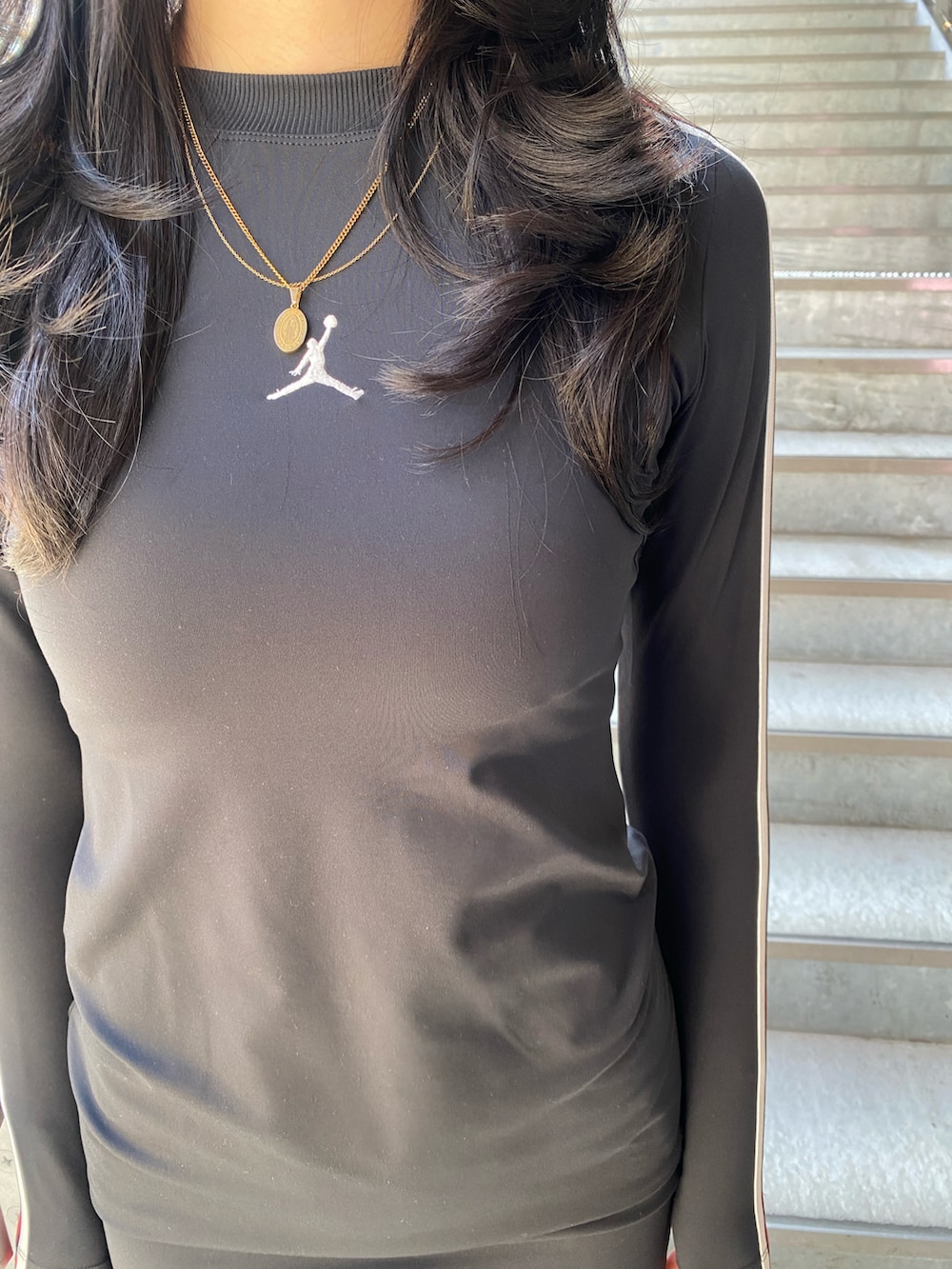 ブラック系のワンピース、ブラック系のジャケット/アウター、ホワイト系のスニーカーを着用したレディースの冬コーディネートの5枚目の写真