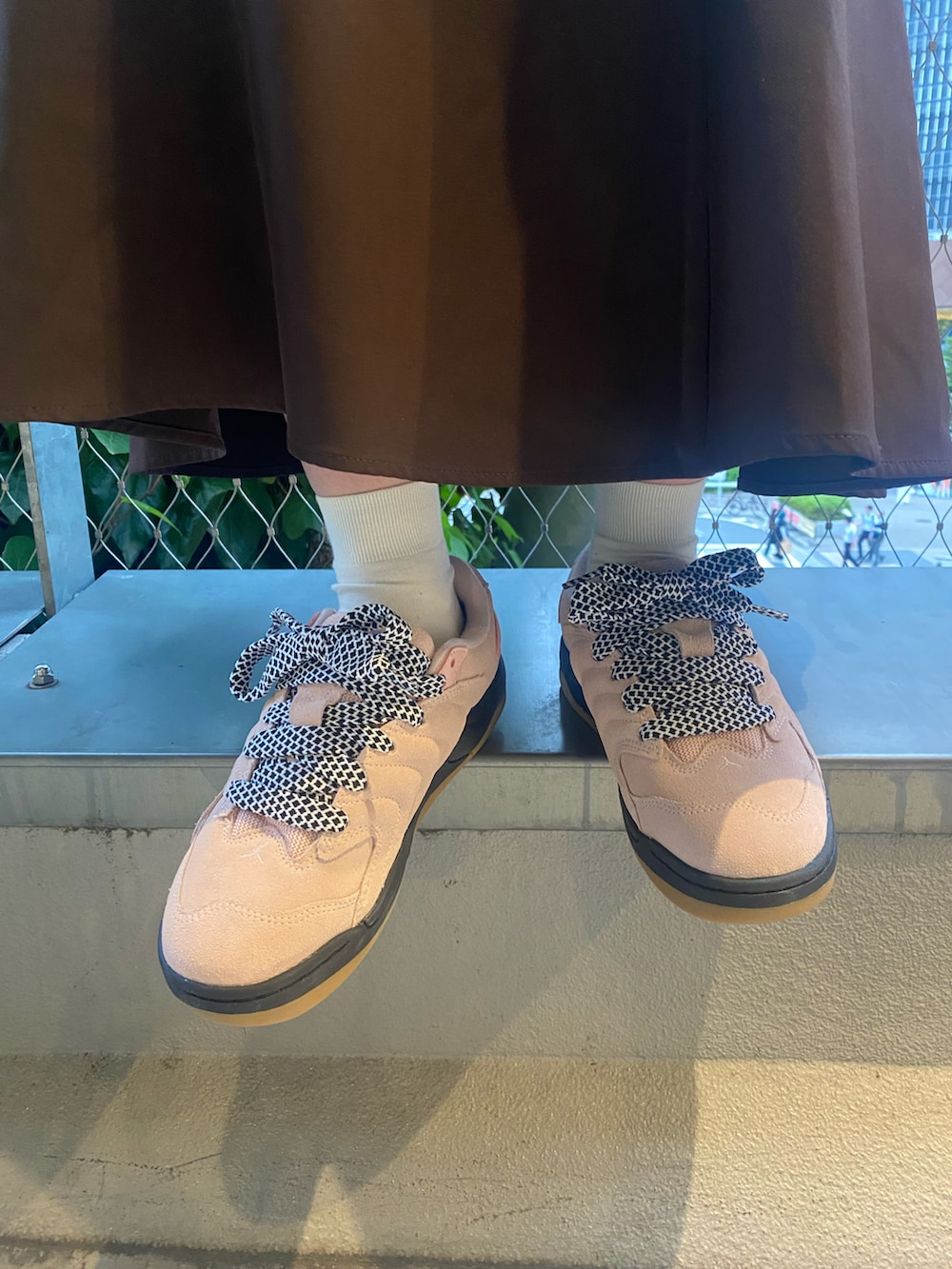 オレンジ系のジャージ、ベージュ系のキャップを着用したレディースの夏コーディネートの3枚目の写真