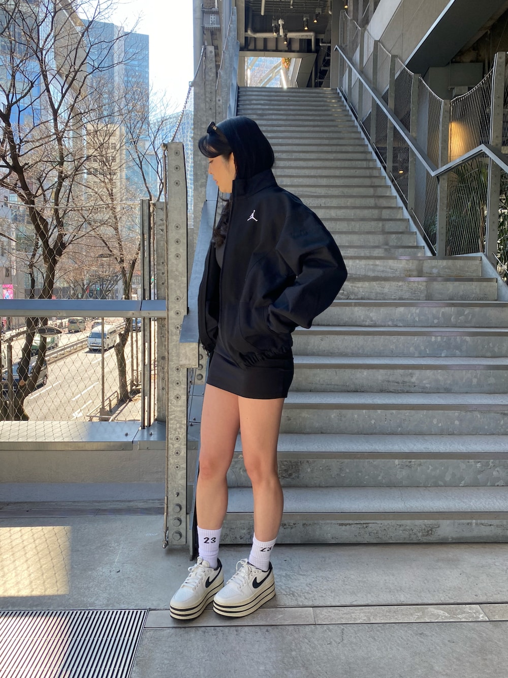 ブラック系のワンピース、ブラック系のジャケット/アウター、ホワイト系のスニーカーを着用したレディースの冬コーディネートの3枚目の写真