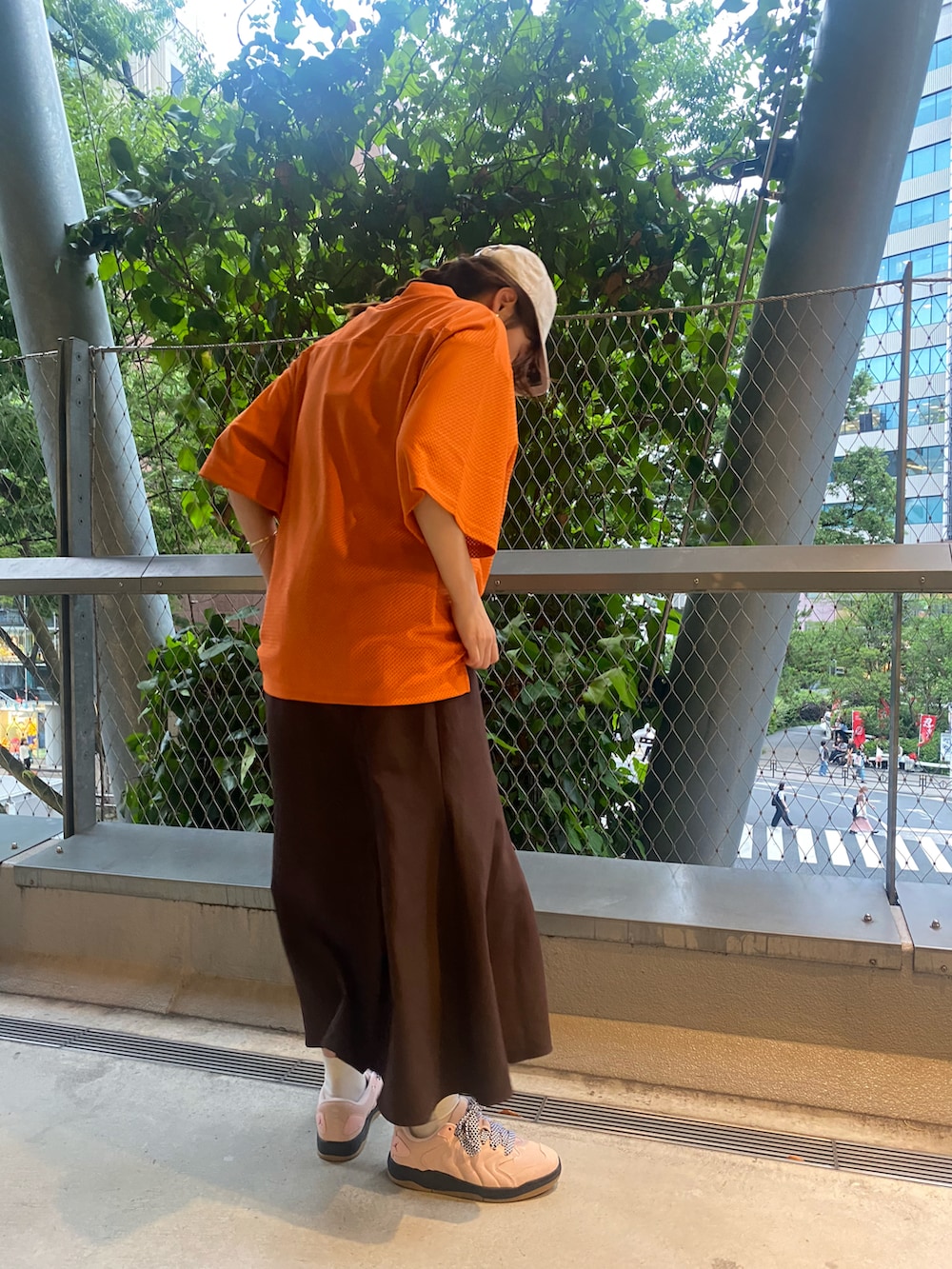 オレンジ系のジャージ、ベージュ系のキャップを着用したレディースの夏コーディネートの2枚目の写真