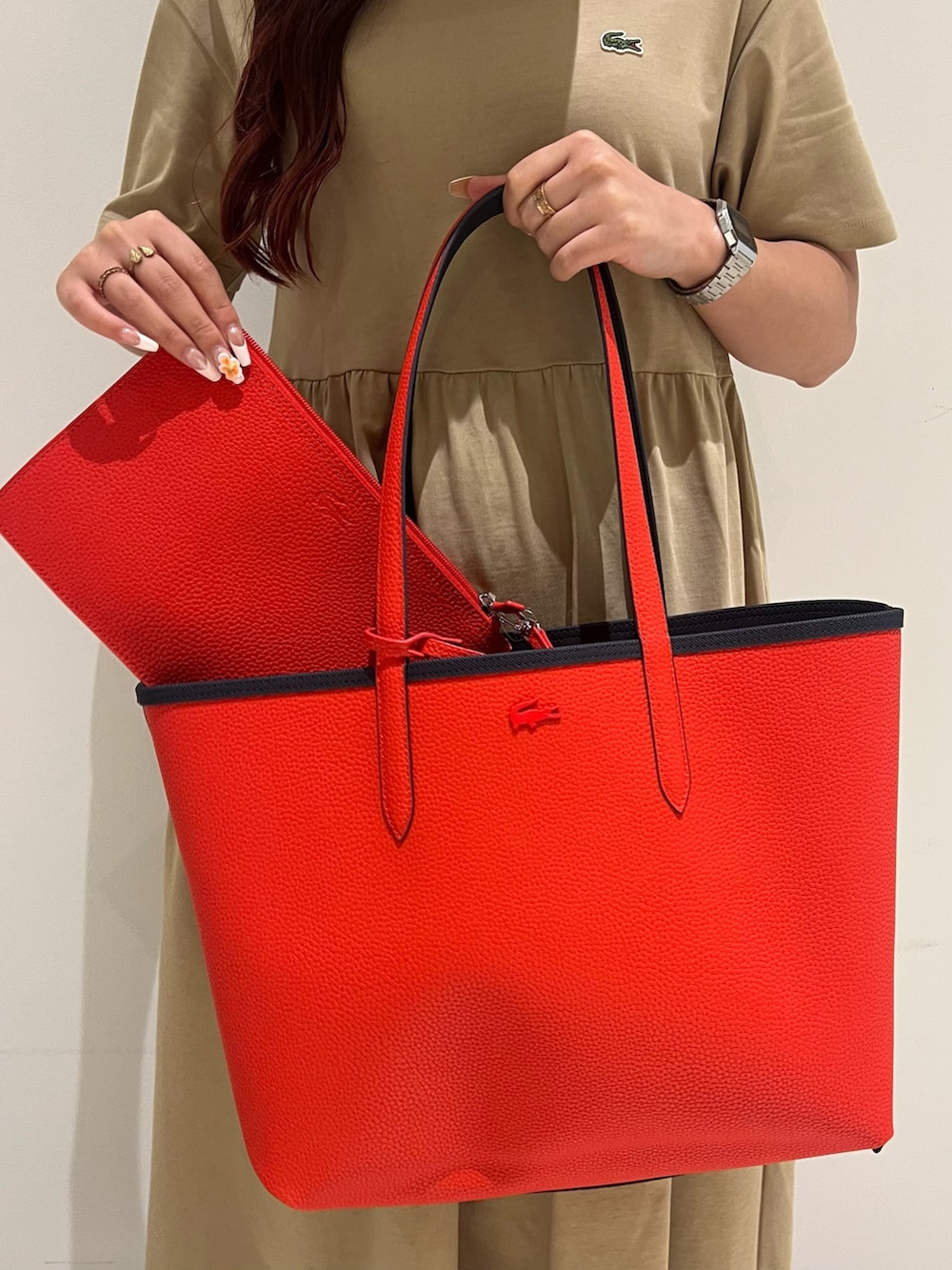 ホワイト系のスニーカー、ベージュ系のワンピース、ブルー系のトートバッグを着用したレディースの夏コーディネートの5枚目の写真