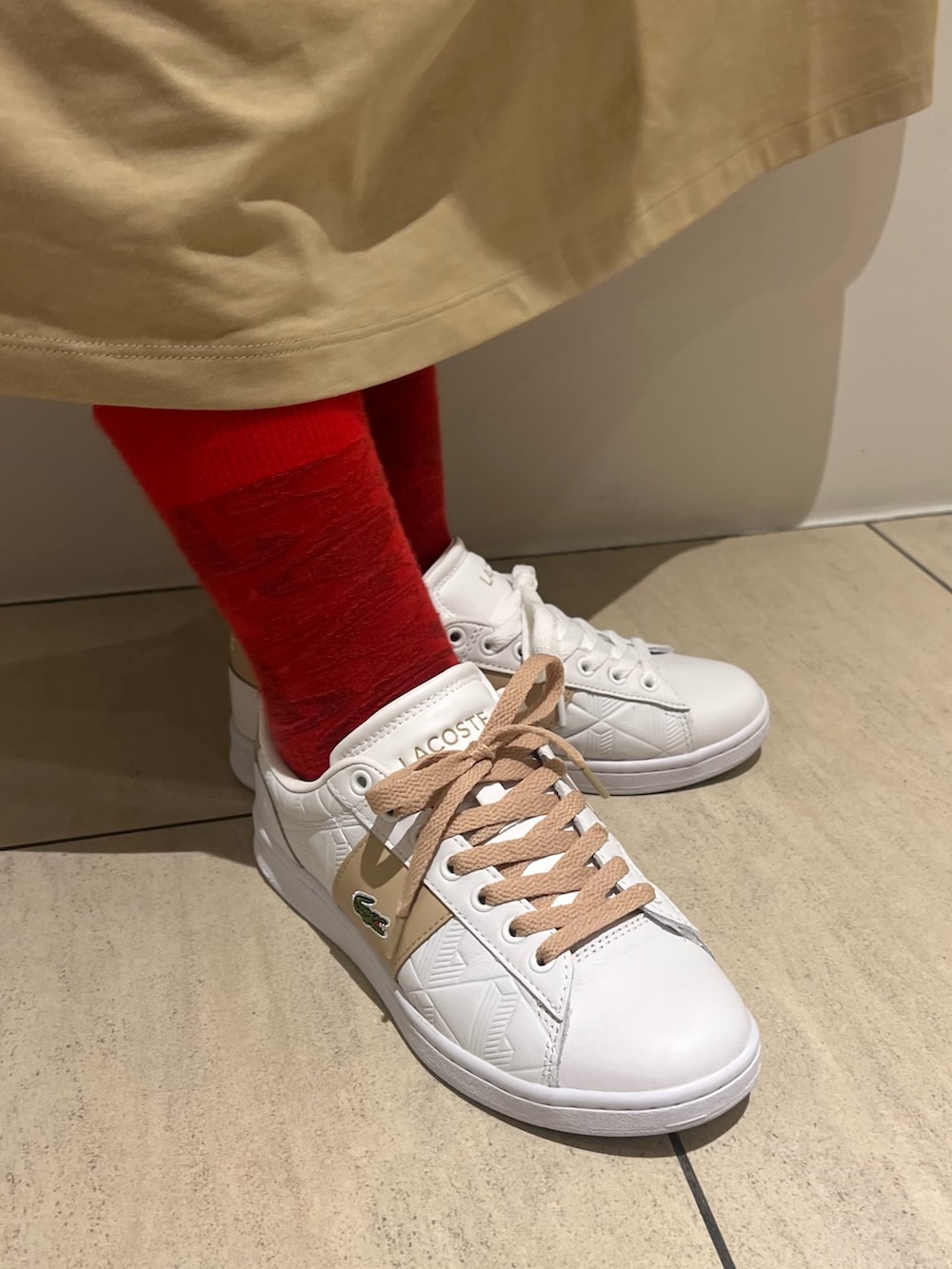 ホワイト系のスニーカー、ベージュ系のワンピース、ブルー系のトートバッグを着用したレディースの夏コーディネートの6枚目の写真