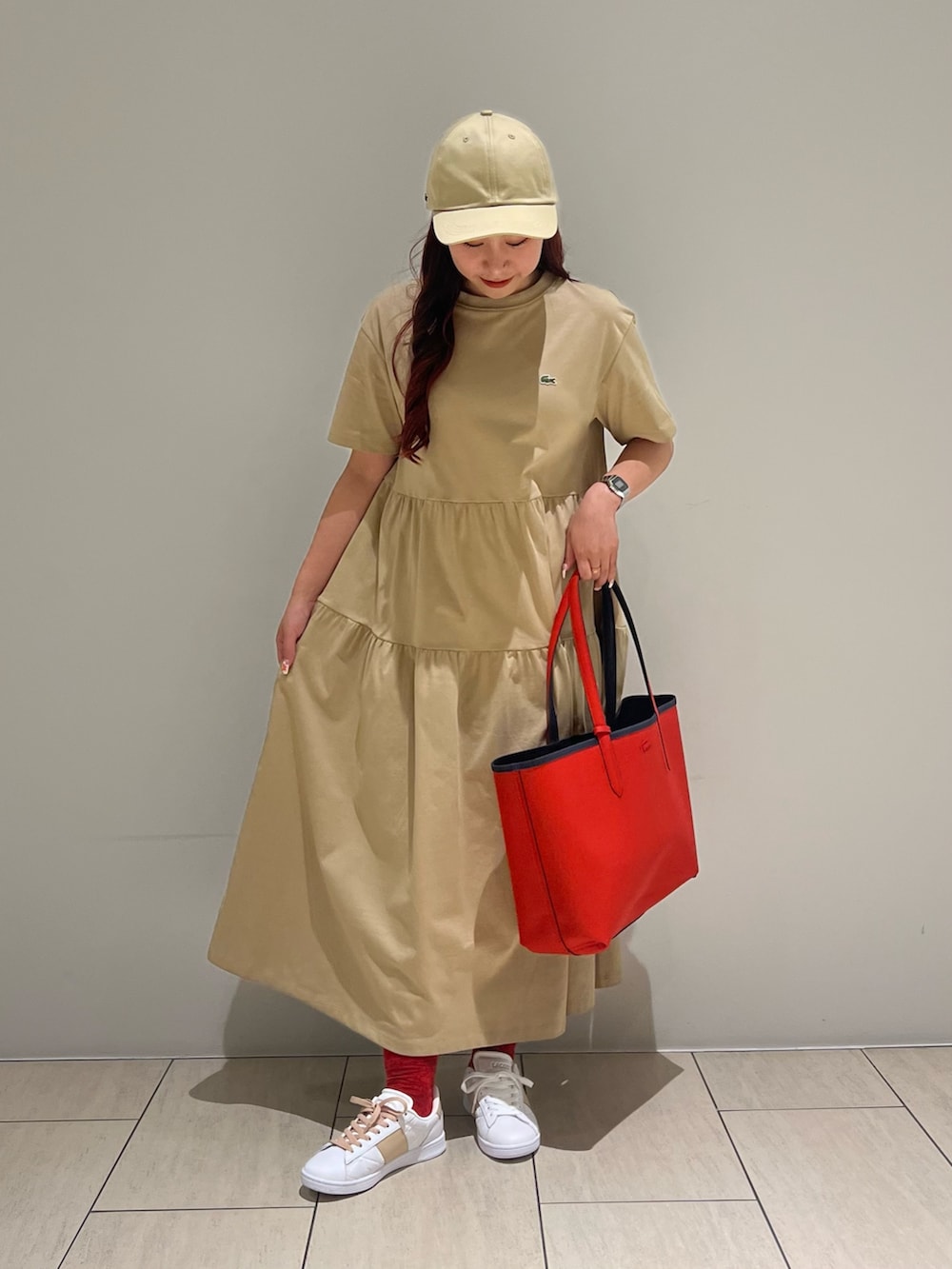 ホワイト系のスニーカー、ベージュ系のワンピース、ブルー系のトートバッグを着用したレディースの夏コーディネートの2枚目の写真