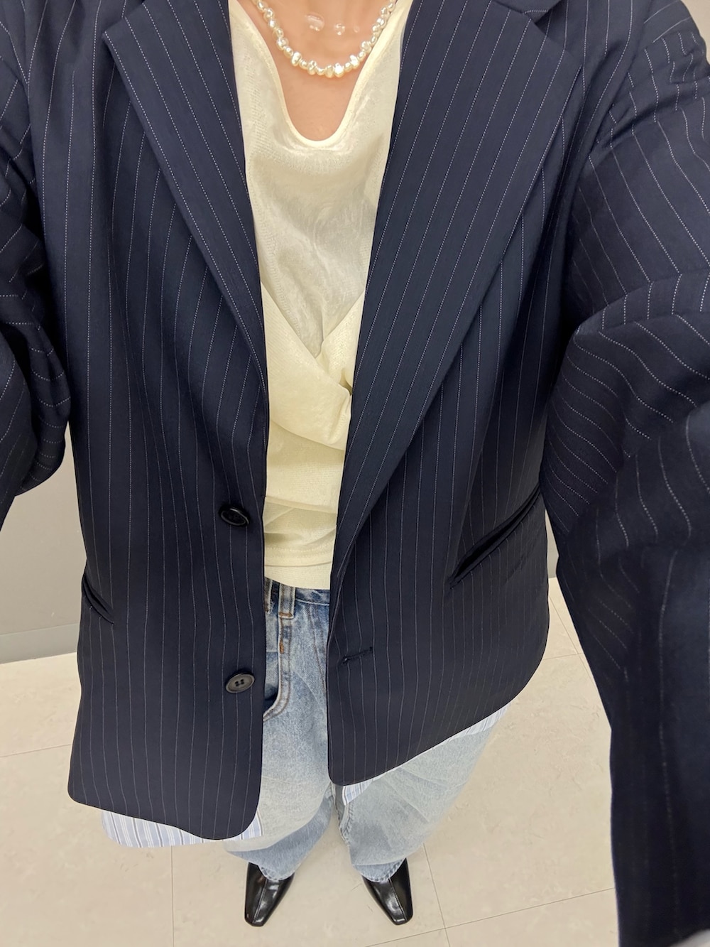 ブルー系のデニムパンツ、ブルー系のその他アウター、ホワイト系のTシャツ/カットソーを着用したレディースの冬コーディネートの6枚目の写真