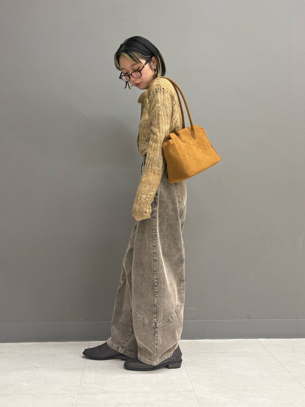 ブラウン系のその他パンツ、ベージュ系のカーディガン/ボレロ、イエロー系のボストンバッグを着用したレディースの秋コーディネートの3枚目の写真