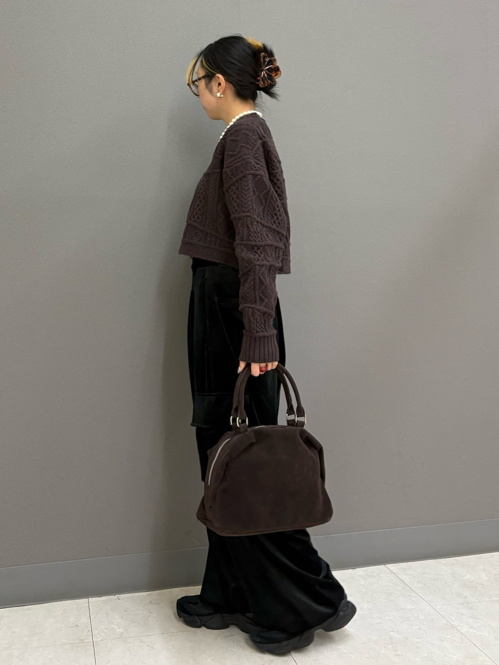 ブラック系のその他パンツ、ブラウン系のニット/セーター、ブラウン系のボストンバッグを着用したレディースの冬コーディネートの3枚目の写真