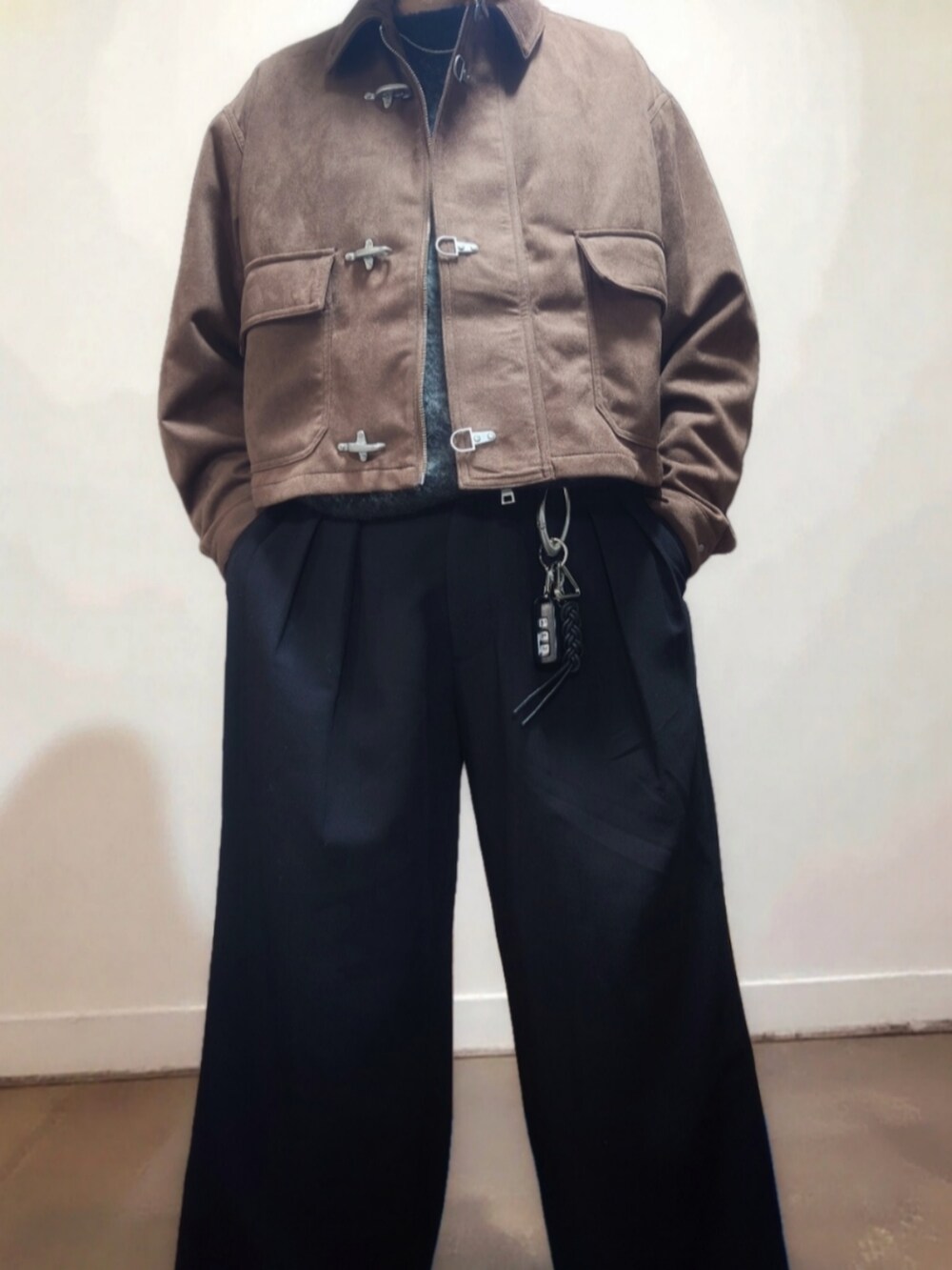 ブラウン系のブルゾン、グレー系のニット/セーター、ブラック系のスラックスを着用したメンズの冬コーディネートの5枚目の写真