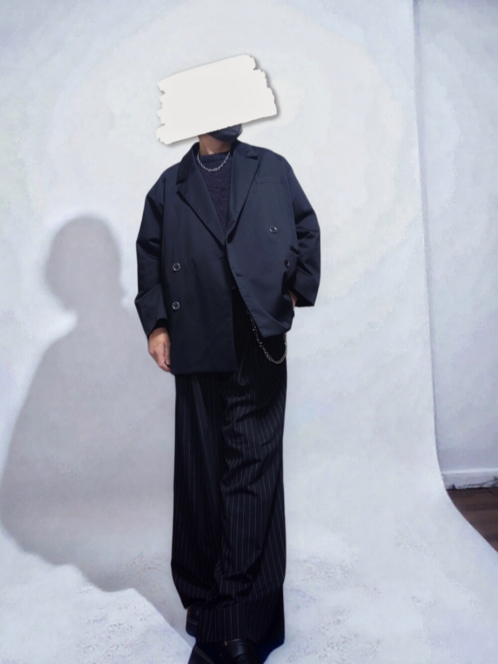 ブラック系のテーラードジャケット、ブラック系のニット/セーター、ブラック系のスラックスを着用したメンズの秋コーディネートの2枚目の写真