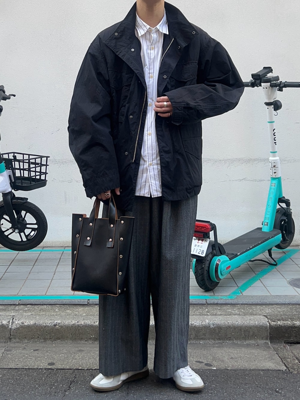 ブラック系のハンドバッグ、ホワイト系のスニーカー、ホワイト系のシャツ/ブラウスを着用したメンズの秋コーディネートの2枚目の写真