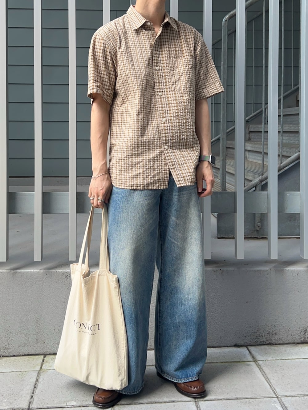 ベージュ系のシャツ/ブラウス、ブルー系のデニムパンツ、ブラウン系のローファーを着用したメンズの夏コーディネートの2枚目の写真