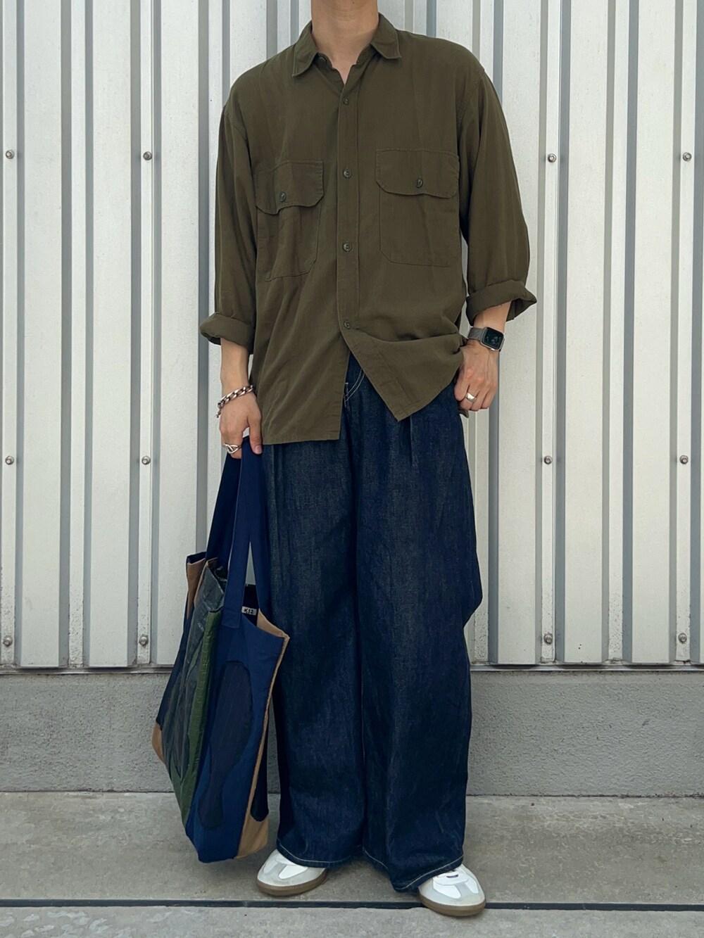 ホワイト系のスニーカー、グリーン系のトートバッグ、グリーン系のシャツ/ブラウスを着用したメンズの秋コーディネートの2枚目の写真