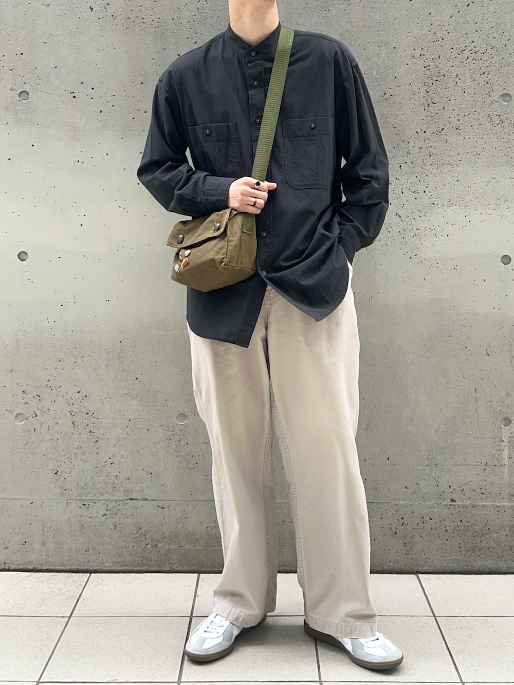 ブラック系のシャツ/ブラウス、ホワイト系のパンツ、ホワイト系のスニーカーを着用したメンズの春コーディネートの2枚目の写真