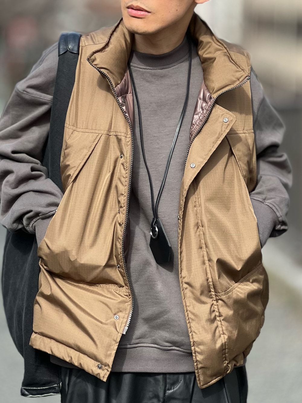 ブラック系のその他パンツ、ブラウン系のダウンベスト、グレー系のスウェットを着用したメンズの春コーディネートの4枚目の写真