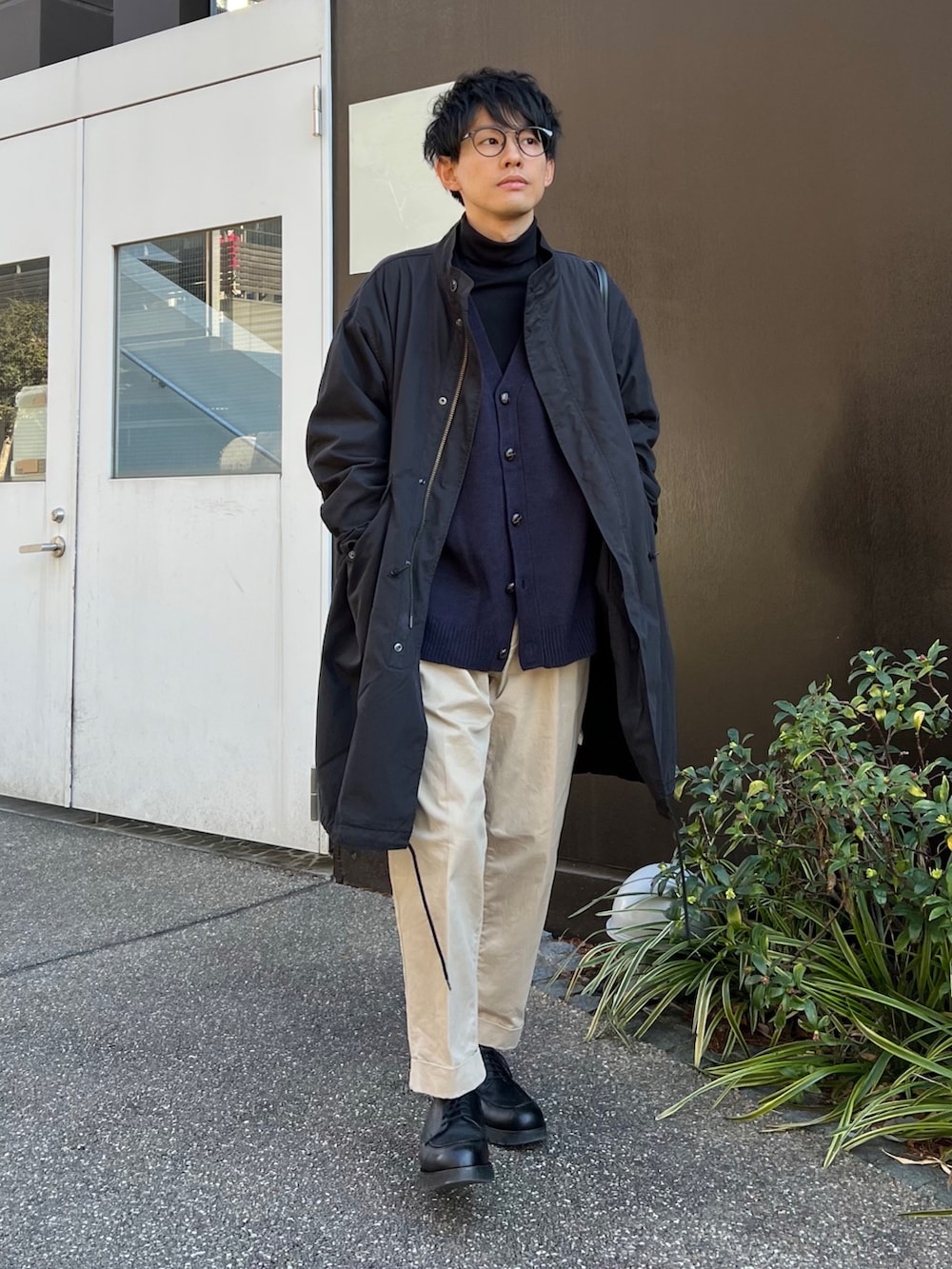 ブラック系のモッズコート、ブラック系のトートバッグ、ブルー系のカーディガン/ボレロを着用したメンズの冬コーディネートの2枚目の写真