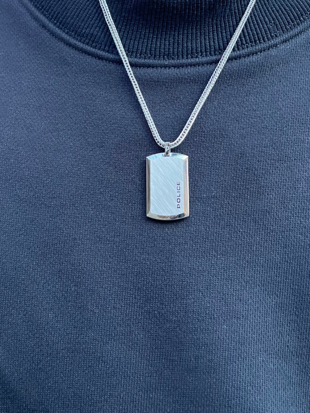 ブラック系のスウェット、ブラック系のドレスシューズ、ブルー系のデニムパンツを着用したメンズの秋コーディネートの2枚目の写真