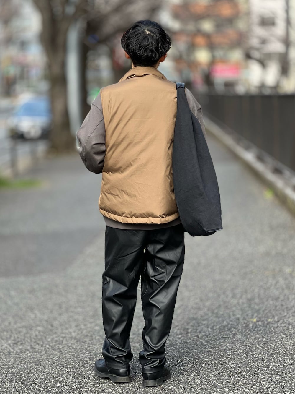 ブラック系のその他パンツ、ブラウン系のダウンベスト、グレー系のスウェットを着用したメンズの春コーディネートの3枚目の写真