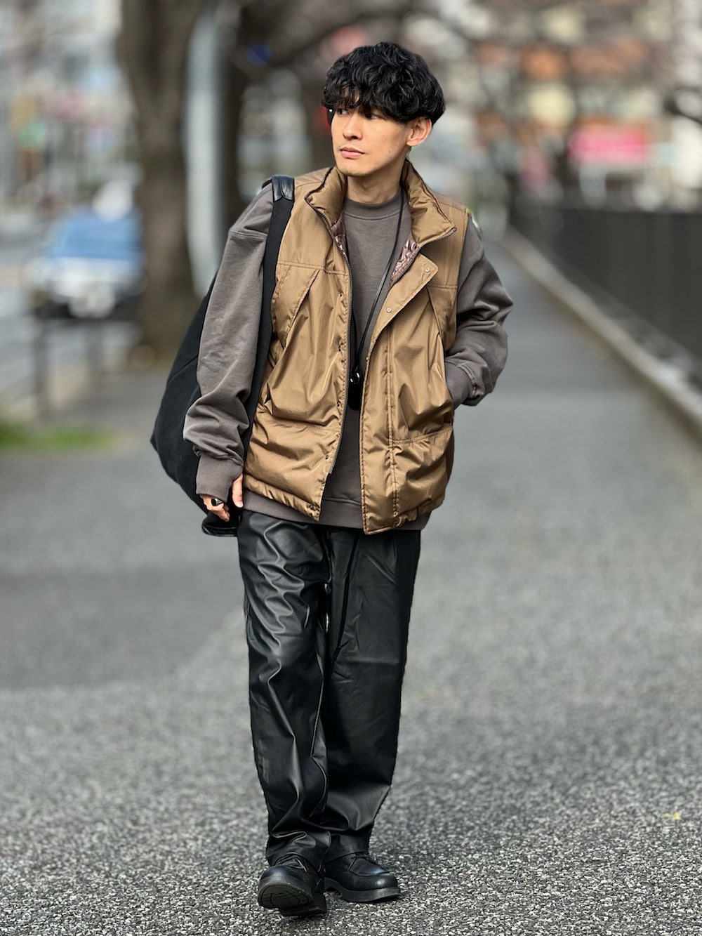 ブラック系のその他パンツ、ブラウン系のダウンベスト、グレー系のスウェットを着用したメンズの春コーディネートの2枚目の写真