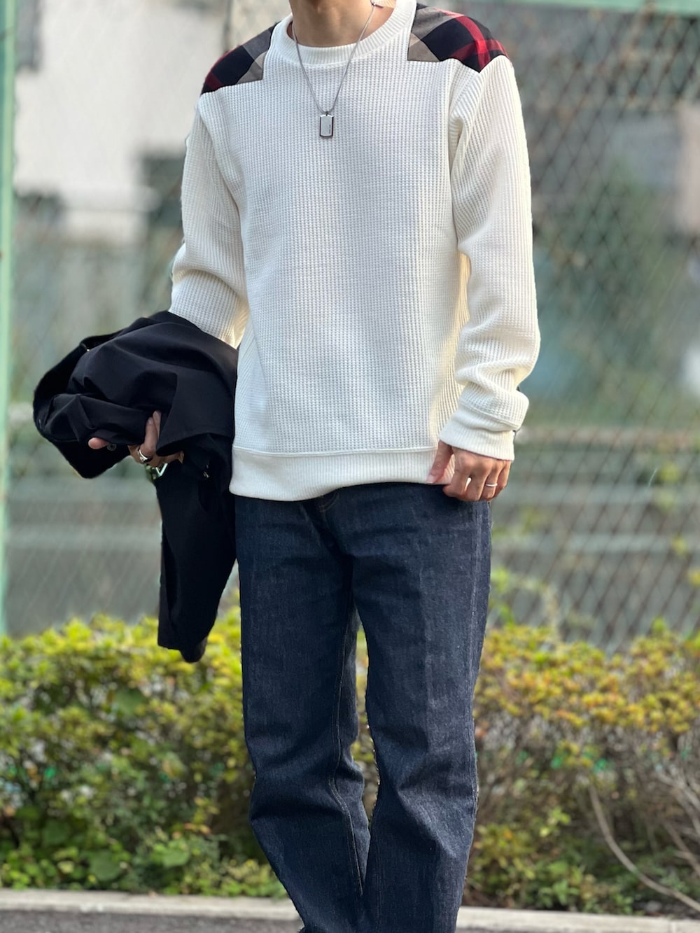 ブラック系のブルゾン、ホワイト系のTシャツ/カットソー、ブルー系のデニムパンツを着用したメンズの秋コーディネートの2枚目の写真