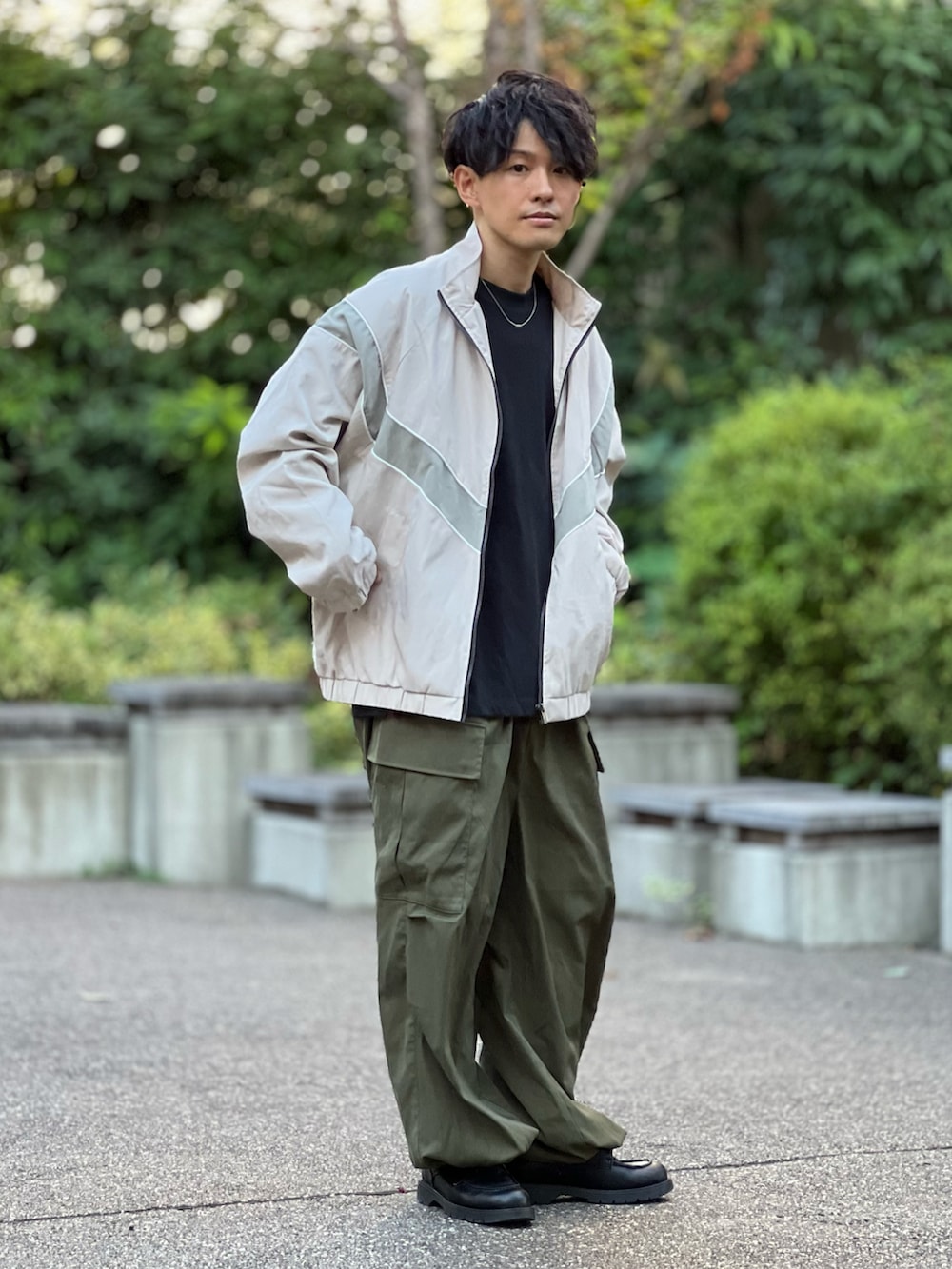 ホワイト系のジャージ、グリーン系のカーゴパンツ、ブラック系のドレスシューズを着用したメンズの秋コーディネートの2枚目の写真