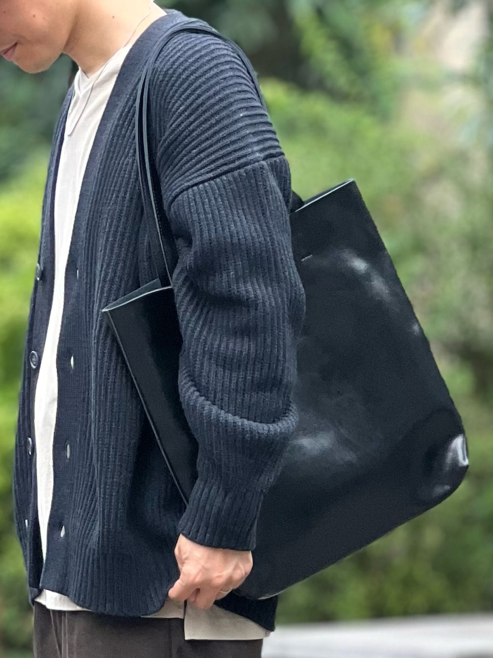 ブラック系のトートバッグ、ブラック系のカーディガン/ボレロ、ブラック系のドレスシューズを着用したメンズの秋コーディネートの3枚目の写真