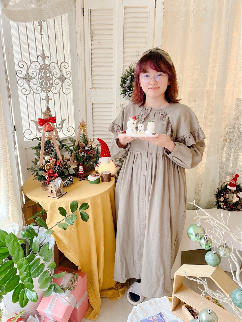 グリーン系のワンピース、ベージュ系のニット/セーター、ブラウン系のブーツを着用したレディースの冬コーディネートの2枚目の写真