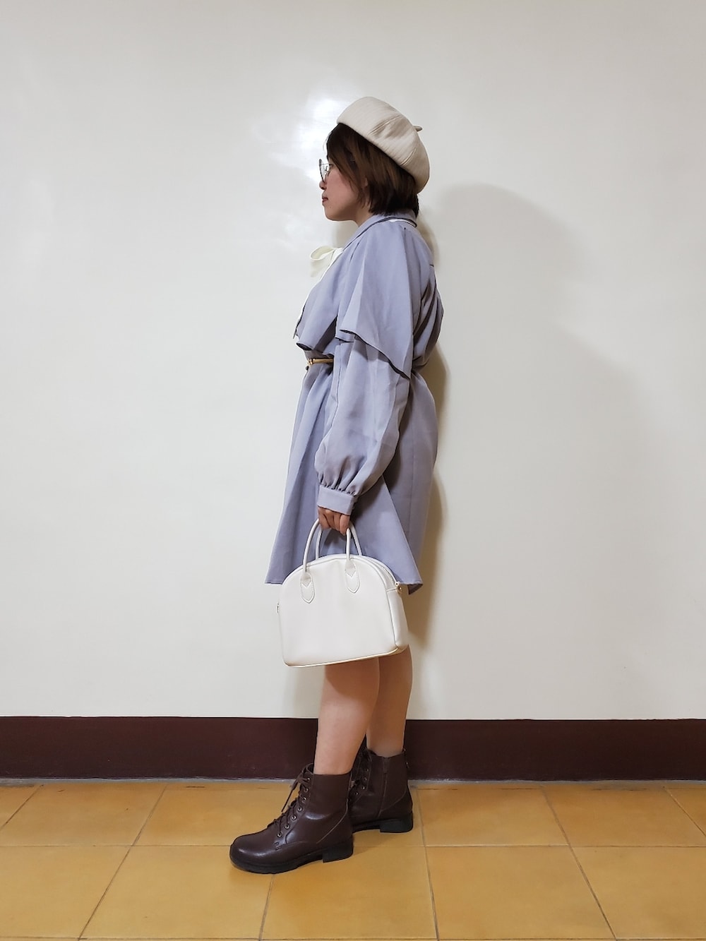 パープル系のワンピース、ブラウン系のブーツ、ホワイト系のトートバッグを着用したレディースの春コーディネートの3枚目の写真