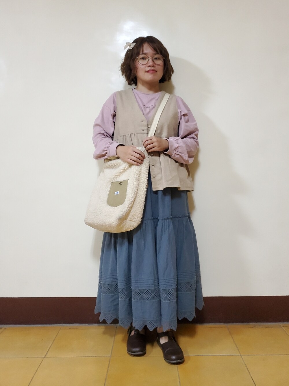 ピンク系のTシャツ/カットソー、ベージュ系のベスト、グリーン系のスカートを着用したレディースの春コーディネートの2枚目の写真