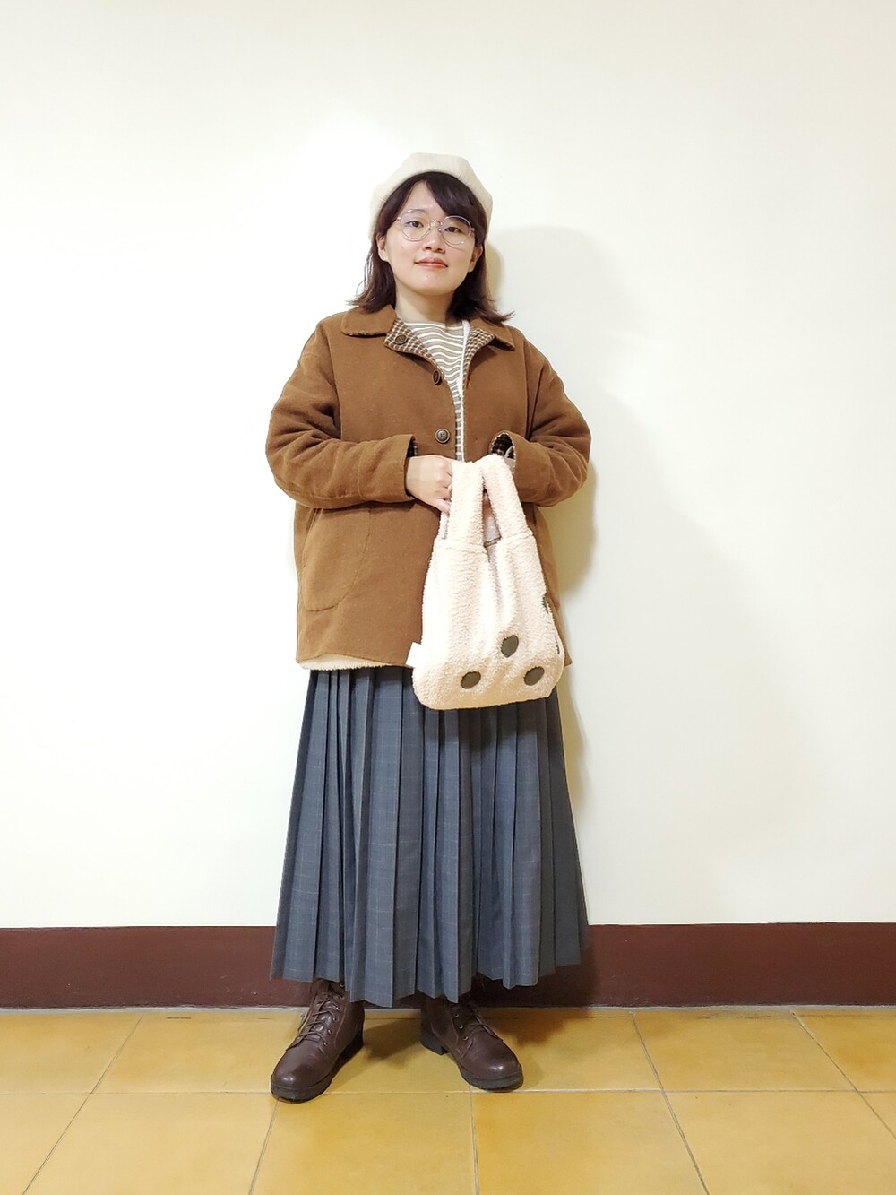 オレンジ系のその他アウター、ホワイト系のベスト、ベージュ系のTシャツ/カットソーを着用したレディースの冬コーディネートの2枚目の写真