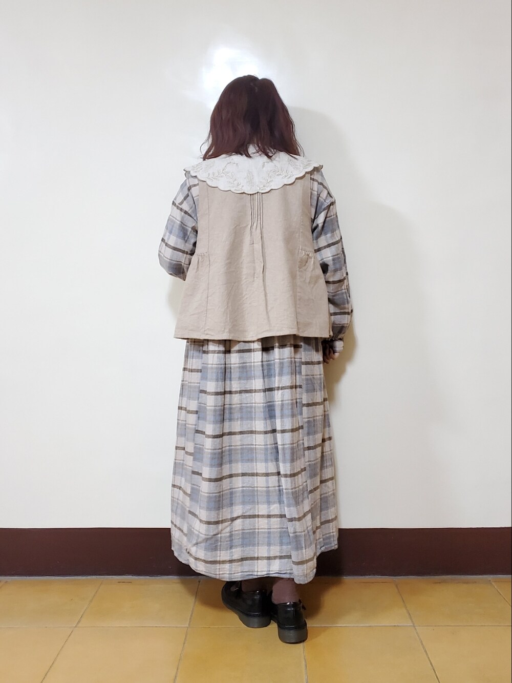 ブルー系のワンピース、ベージュ系のベスト、ブラック系のドレスシューズを着用したレディースの春コーディネートの3枚目の写真