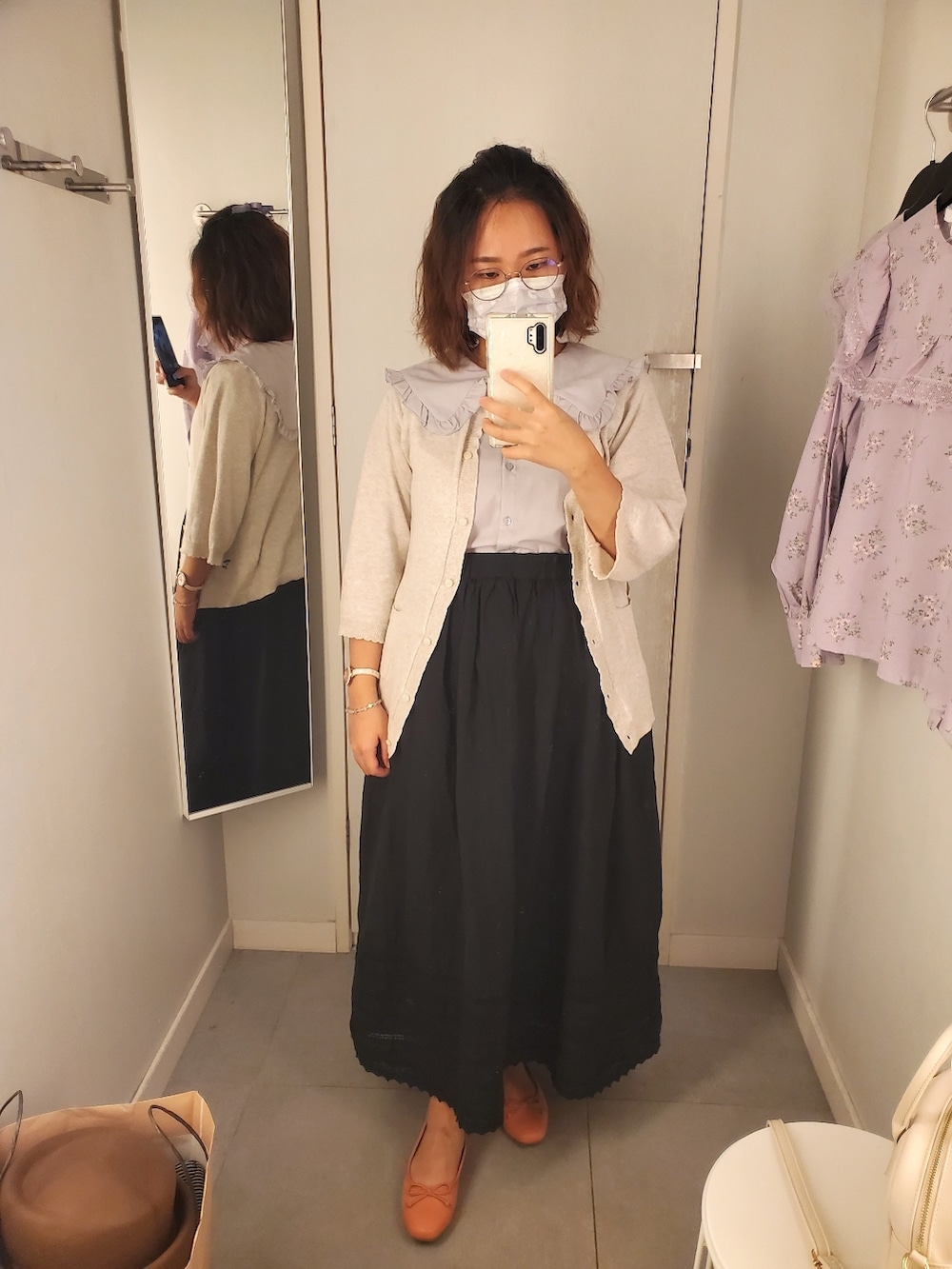 グレー系のシャツ/ブラウス、ホワイト系のカーディガン/ボレロ、ブラック系のスカートを着用したレディースの秋コーディネートの3枚目の写真