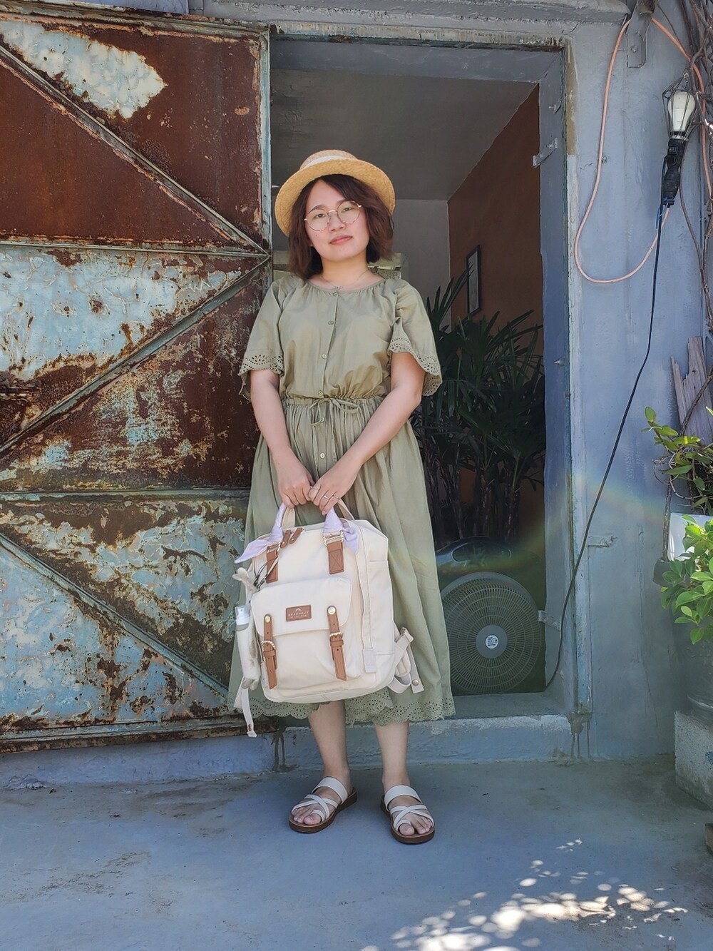 グリーン系のワンピース、ホワイト系のサンダル、ベージュ系のバックパック/リュックを着用したレディースの夏コーディネートの2枚目の写真