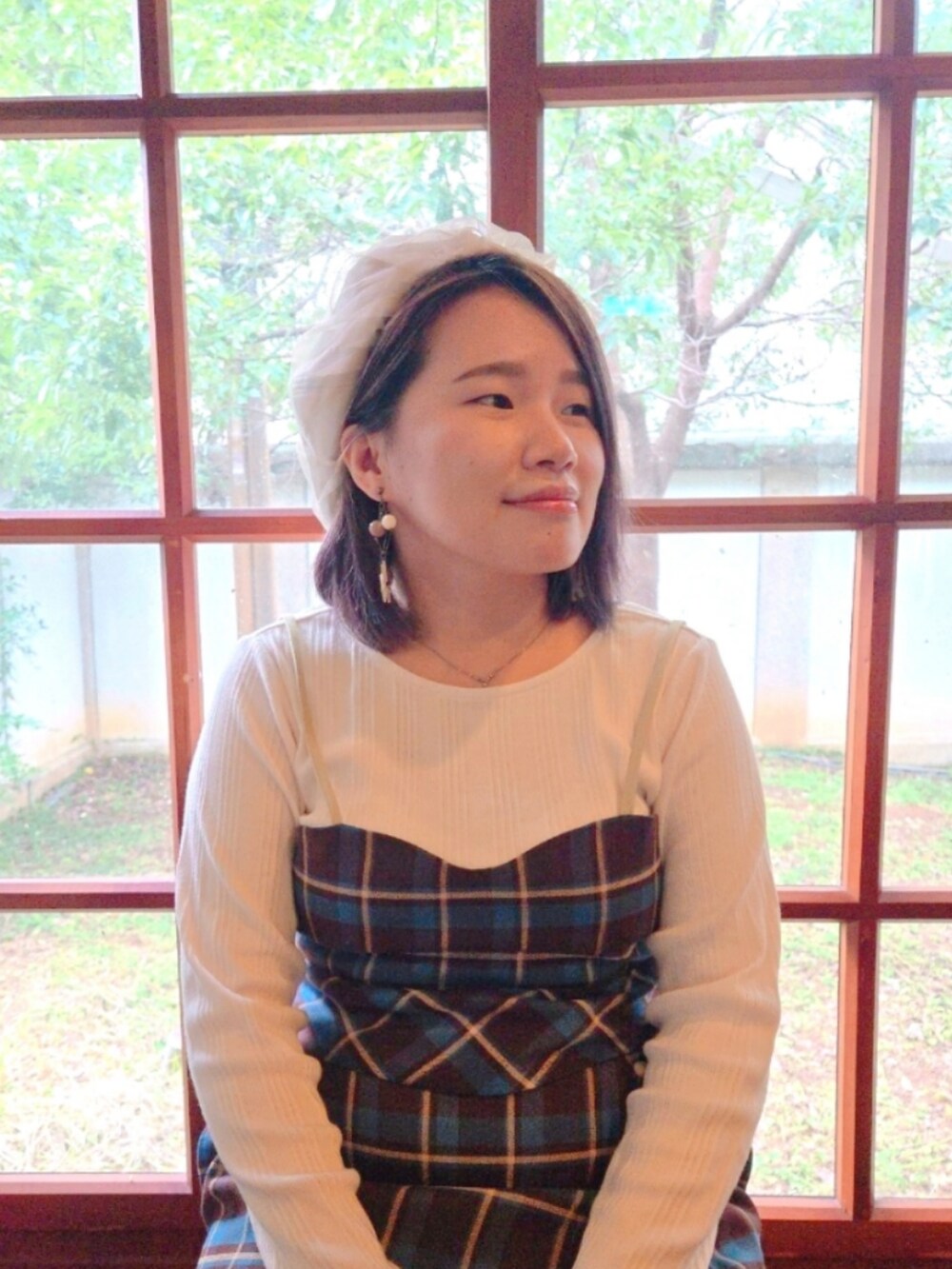 ブラウン系のベスト、ブラウン系のスカート、ホワイト系のTシャツ/カットソーを着用したレディースの冬コーディネートの2枚目の写真