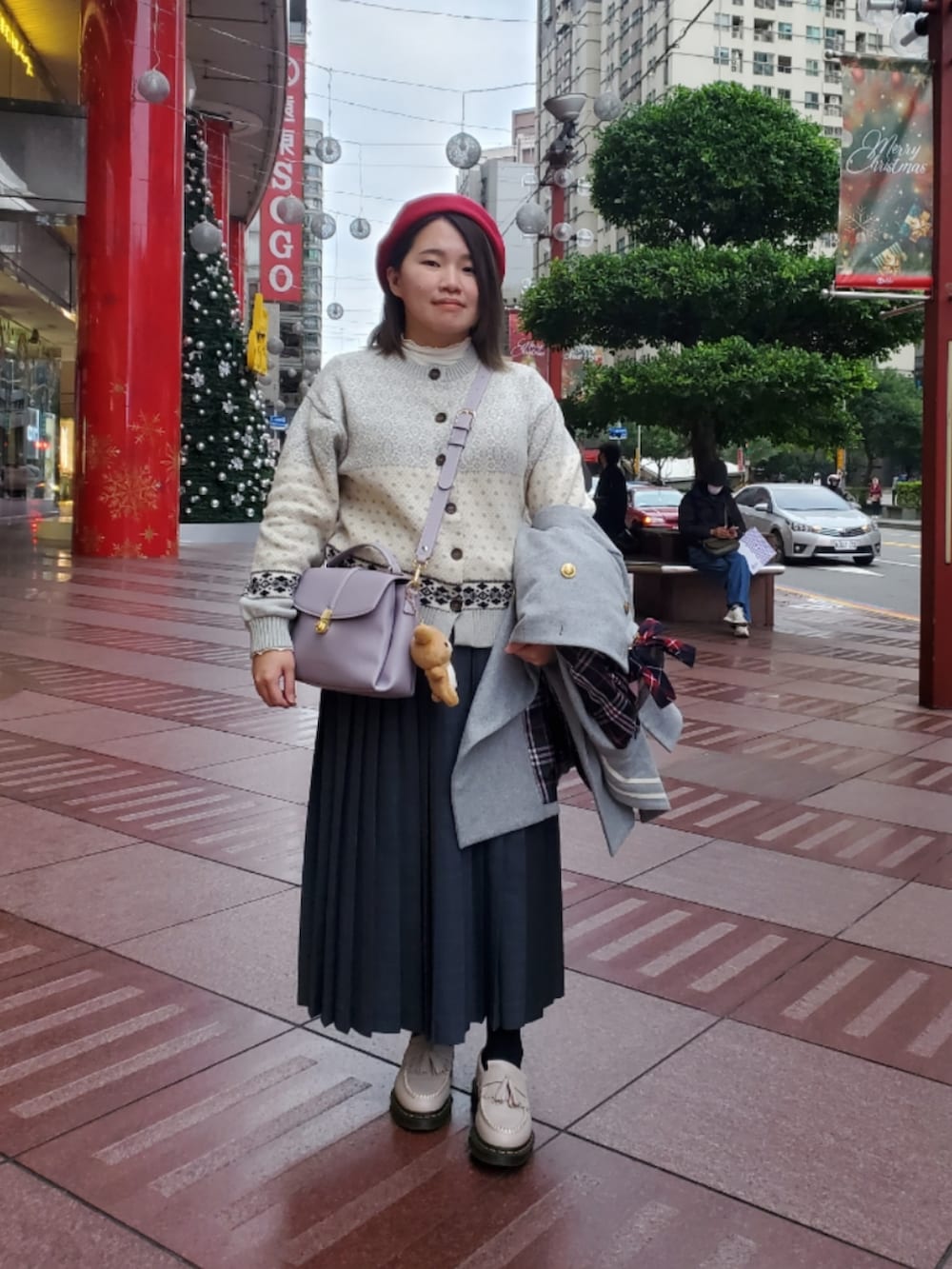 グレー系のダッフルコート、グリーン系のカーディガン/ボレロ、ホワイト系のTシャツ/カットソーを着用したレディースの冬コーディネートの2枚目の写真