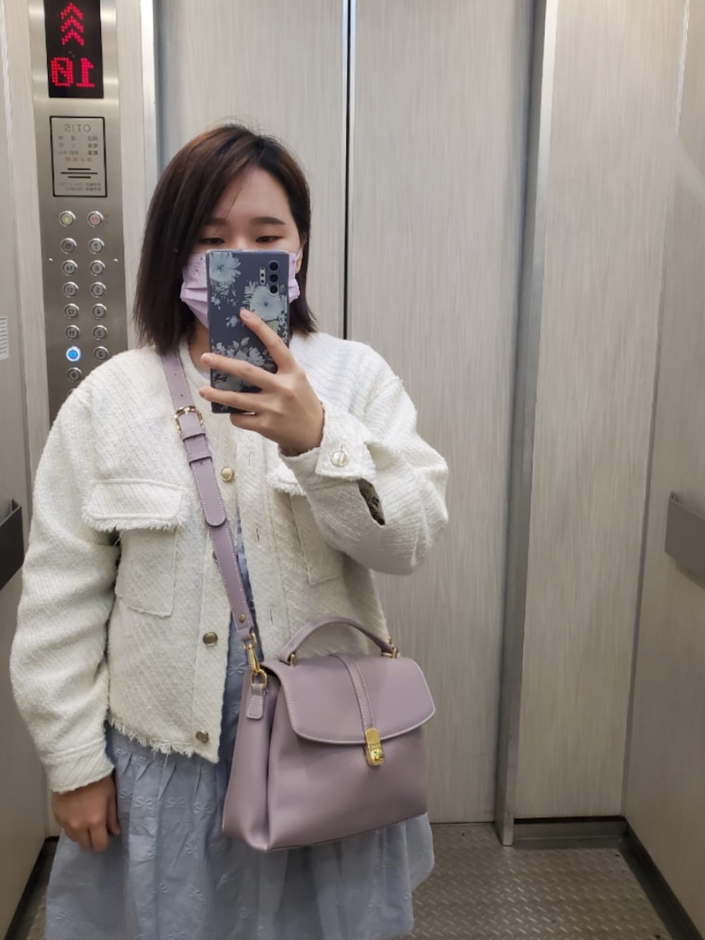 ホワイト系のノーカラージャケット、ブルー系のワンピース/ドレス、ホワイト系のパンプスを着用したレディースの冬コーディネートの3枚目の写真